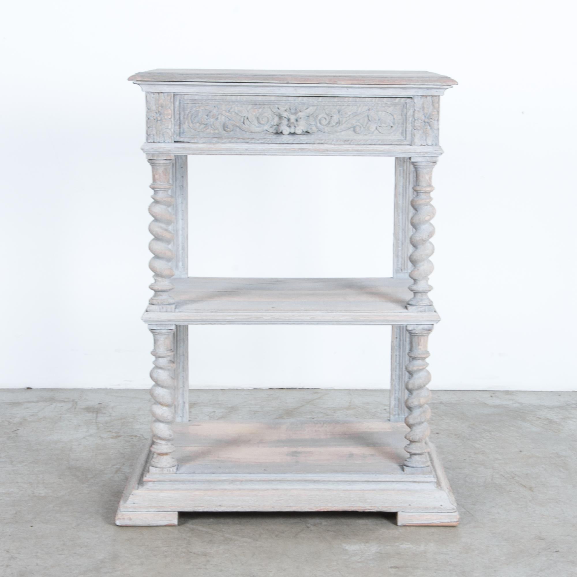 An oak console table with drawer and shelves from Belgium, circa 1900. A stabile design features a solid base, connected with columns to an upper shelf and tabletop, carved from durable hardwood and beautifully rendered in carved ornament,