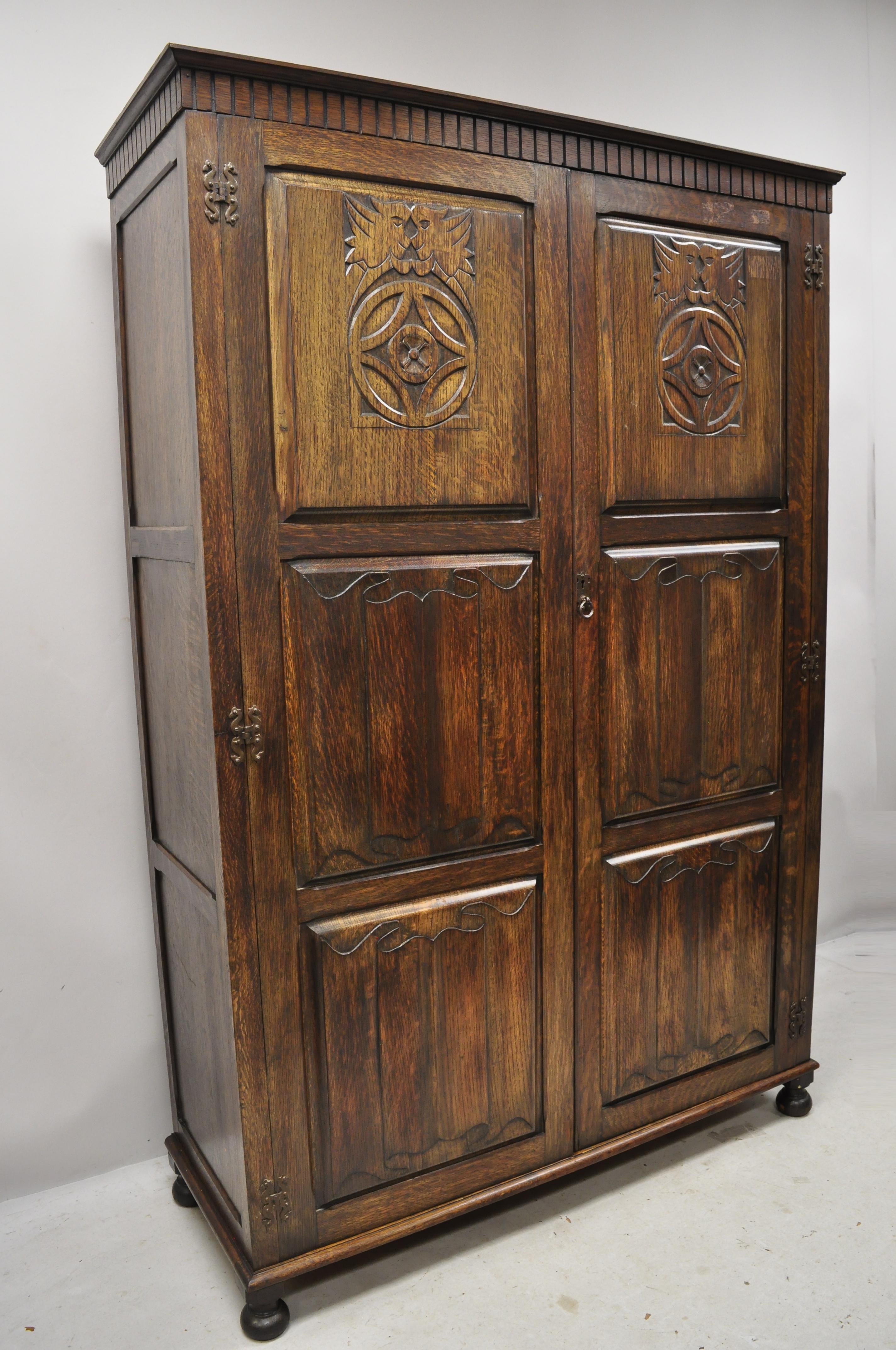 Antique Belgium Renaissance Jacobean figural carved oak large wardrobe cabinet. Item features figural carvings to door fronts, bun feet, mirror to interior door, 3-dimensional 