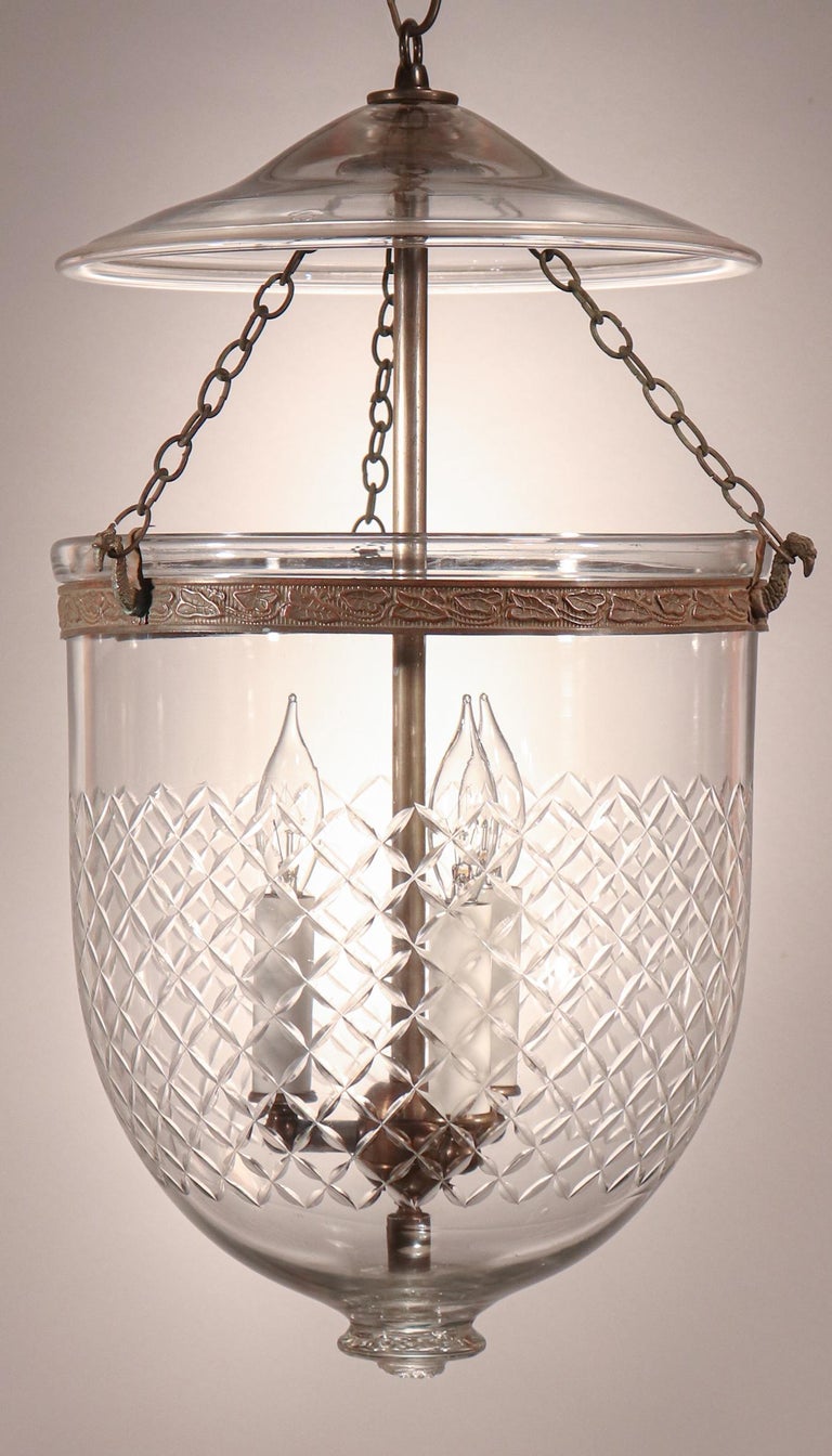 This circa 1880 English bell jar lantern features excellent quality handblown glass that is complemented by a Waterford-style engraved diamond motif. The pendant has retained its original fittings—including embossed brass band, strands of chain, and