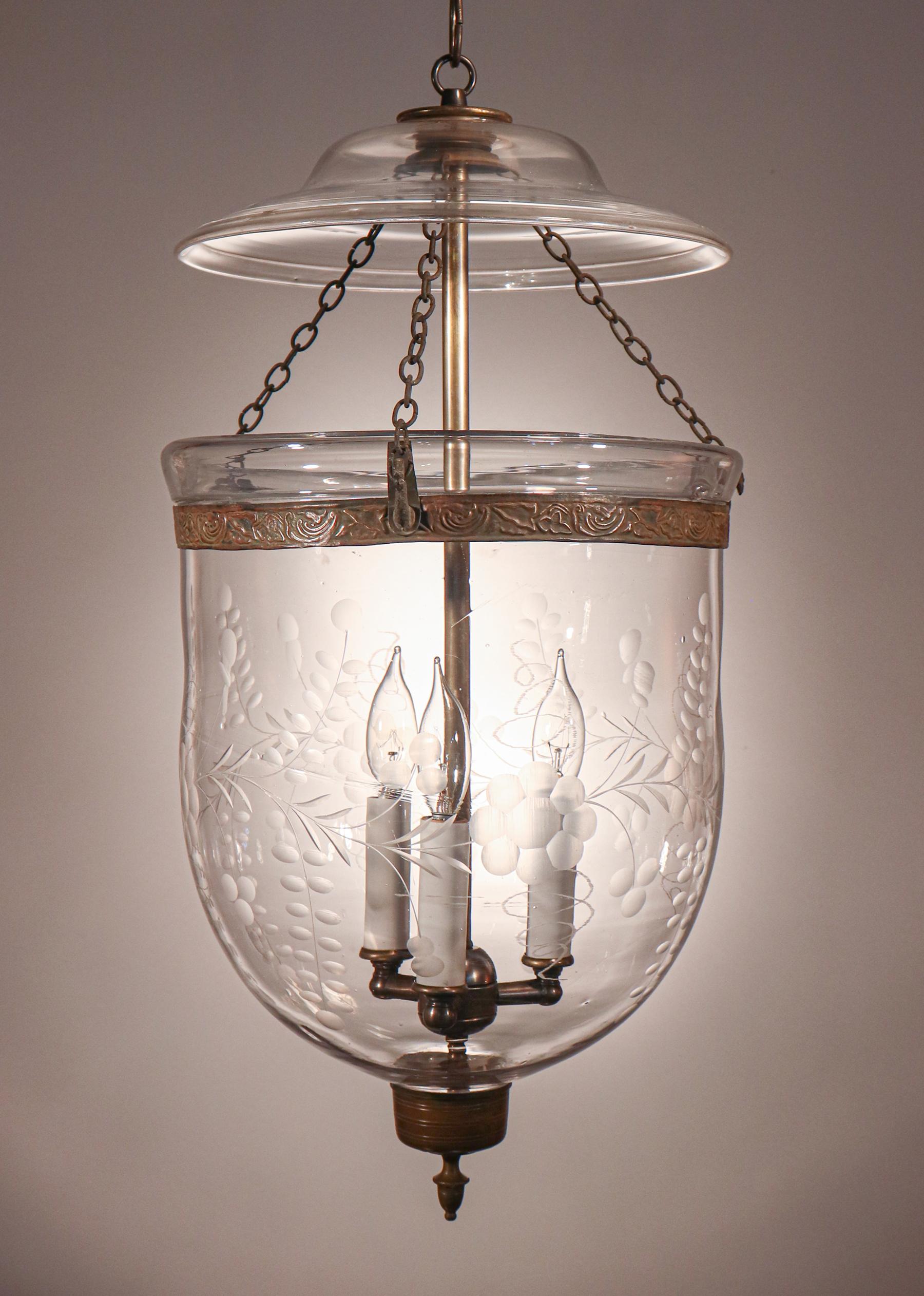 An antique English bell jar lantern with beautiful form and very good quality hand blown glass This circa 1870 pendant, which has a finely etched floral motif, features all-original fittings with the exception of its brass finial/candle holder base,