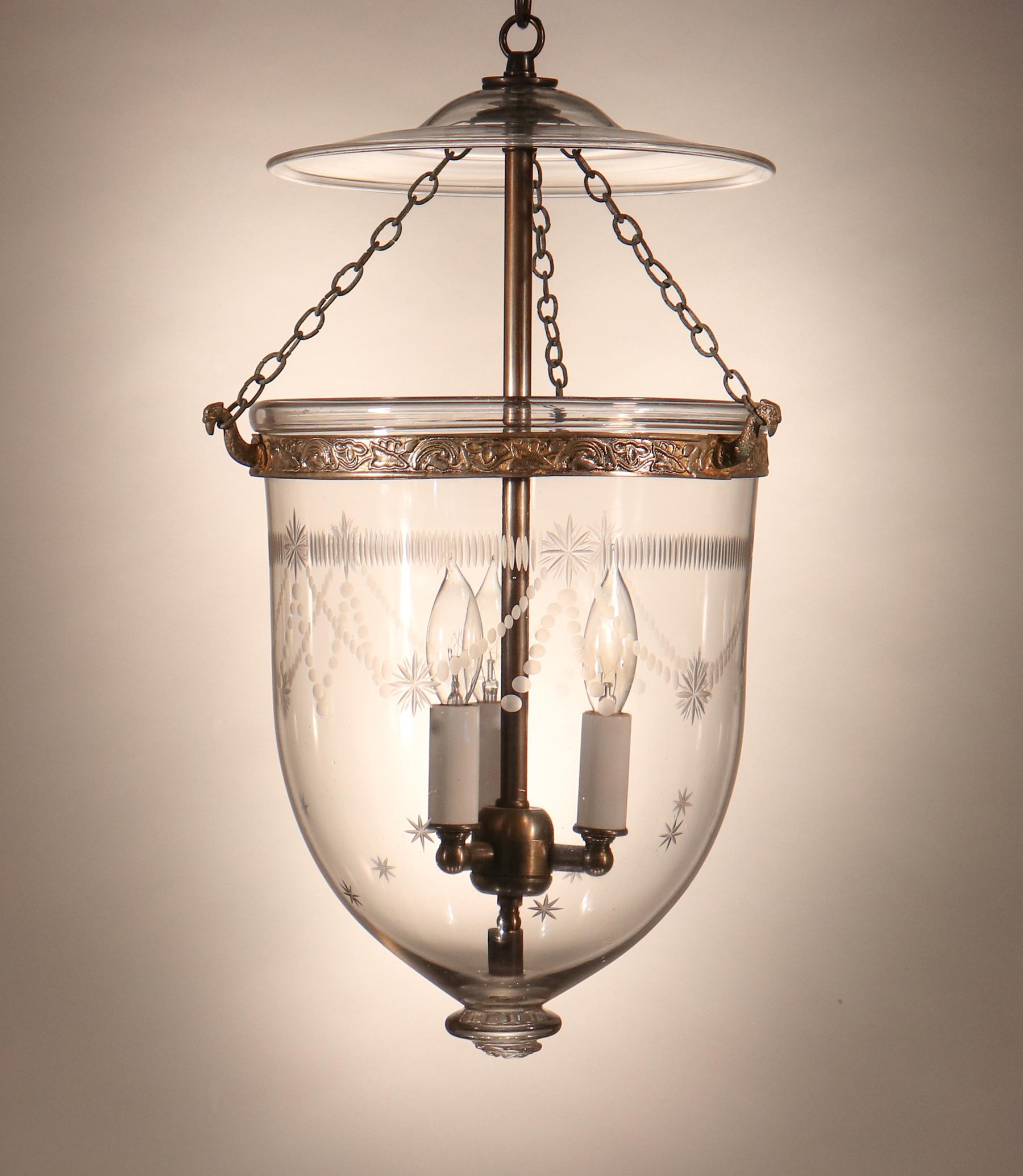 An antique English bell jar lantern, circa 1890, with lovely form and good quality hand blown glass—including several desirable air bubbles in the bell jar, itself, and swirls in the smoke bell/lid. The pendant light features a finely etched