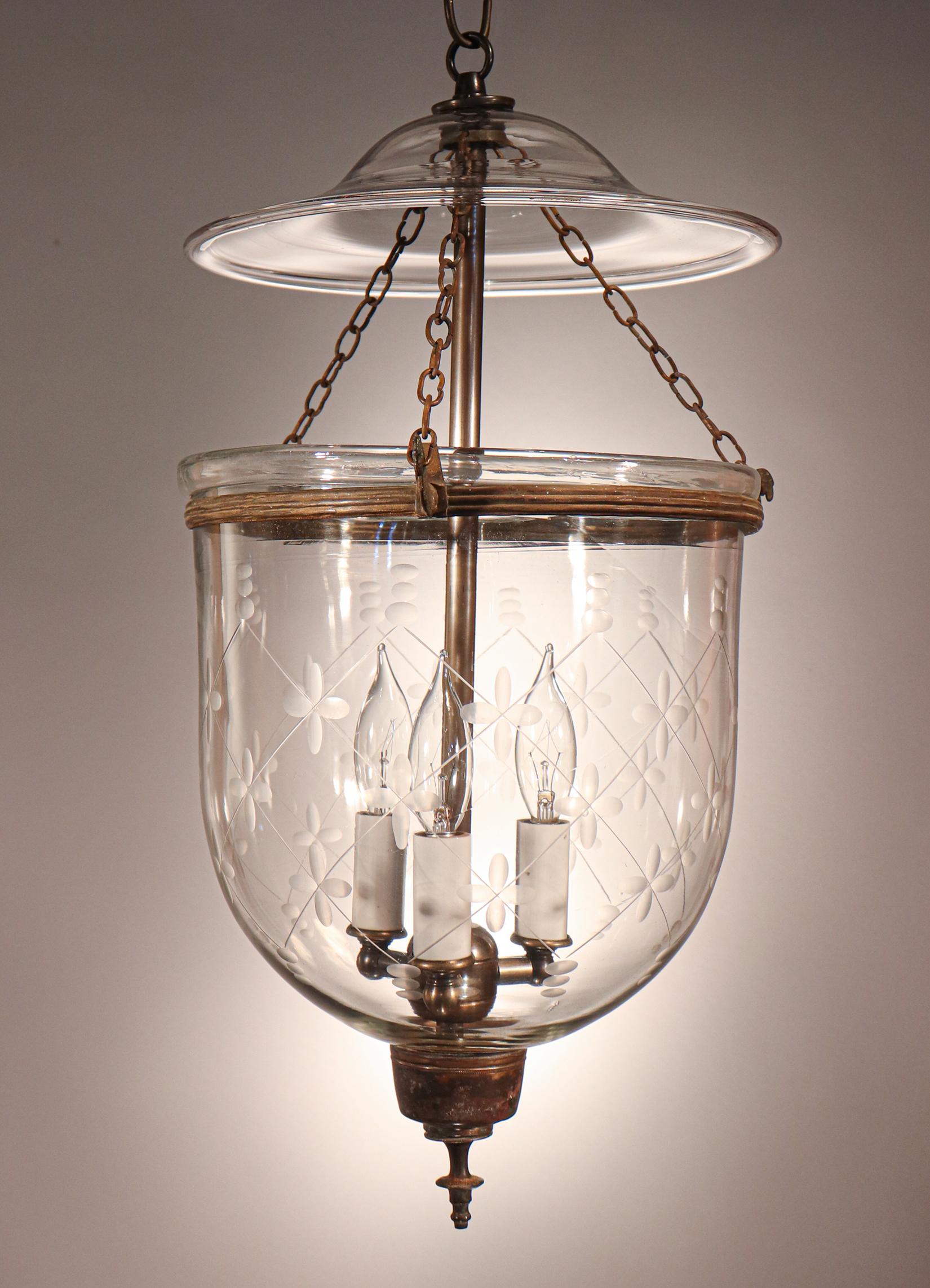 An antique English bell jar lantern with classic form and an etched trellis motif. This circa 1860 pendant features excellent quality hand blown glass and its original rolled brass band and finial/candle holder base with nice patina. The fixture has