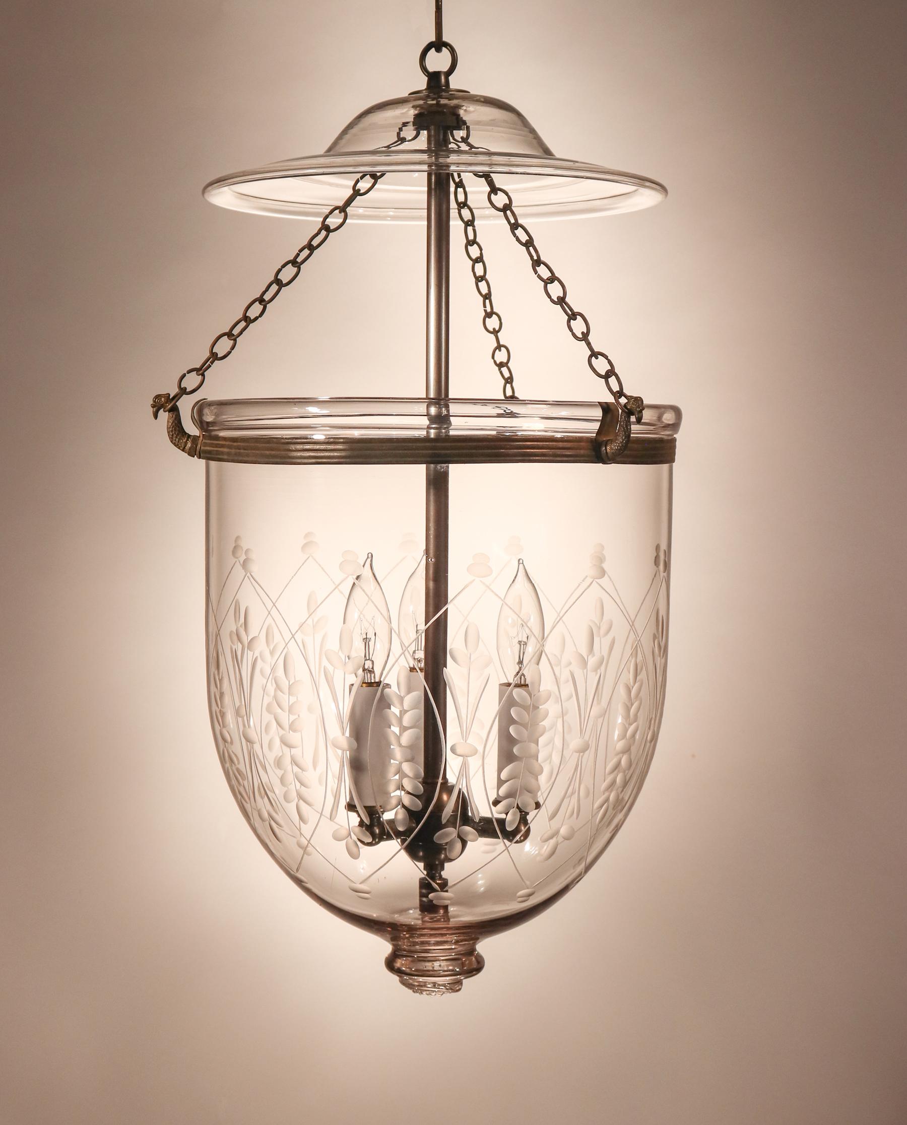 An antique English bell jar lantern, circa 1880, with full form that is complemented by an etched wheat design. This hand blown glass pendant features its original, rolled brass band and smoke bell. Originally for a candle or floating wick, the