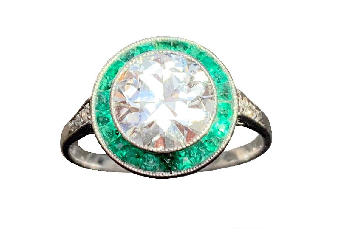 This elegant Belle Époque Diamond and emerald ring is of timeless beauty and elegance.
The brilliant cut diamond has an established weight of 1.78 carat, colour G with small inclusions SI. 
The weight of the diamond is engraved in script on the