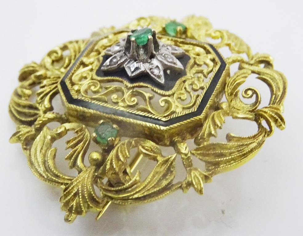 
A very attractive pin pendant from The turn of the 20th century.
It is made in fully marked as well as acid tested 18 karat Gold.
Carved Gold in a floral design the center is a silver star set with  1 ,3 mm round Emerald and a further 7 diamond