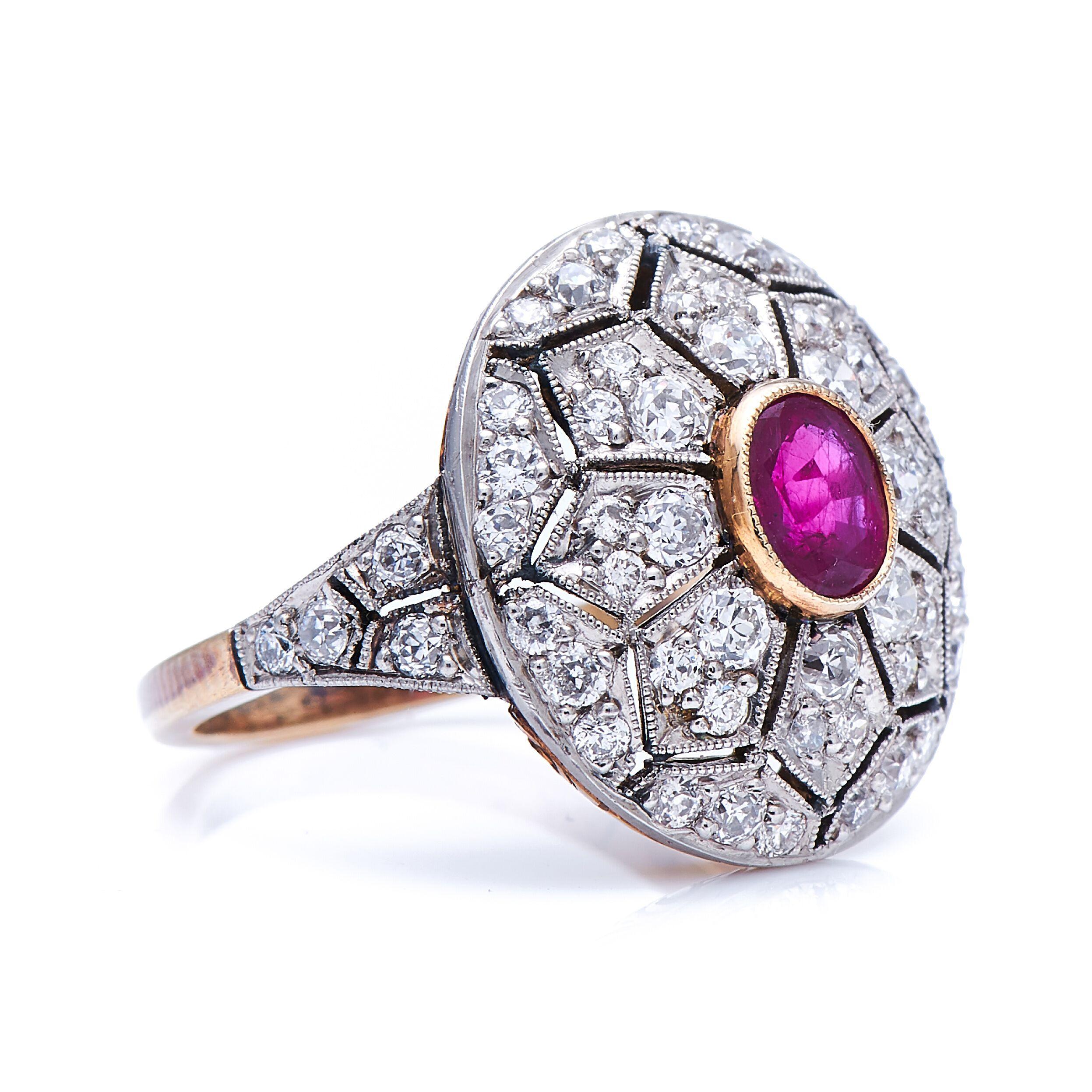 Ruby and diamond ring. This domed setting of this beautiful ruby and diamond ring is hand pierced in a geometric floral pattern. At the centre is an attractive deep red ruby weighing approximately 1 carat, smartly accentuated by a yellow gold