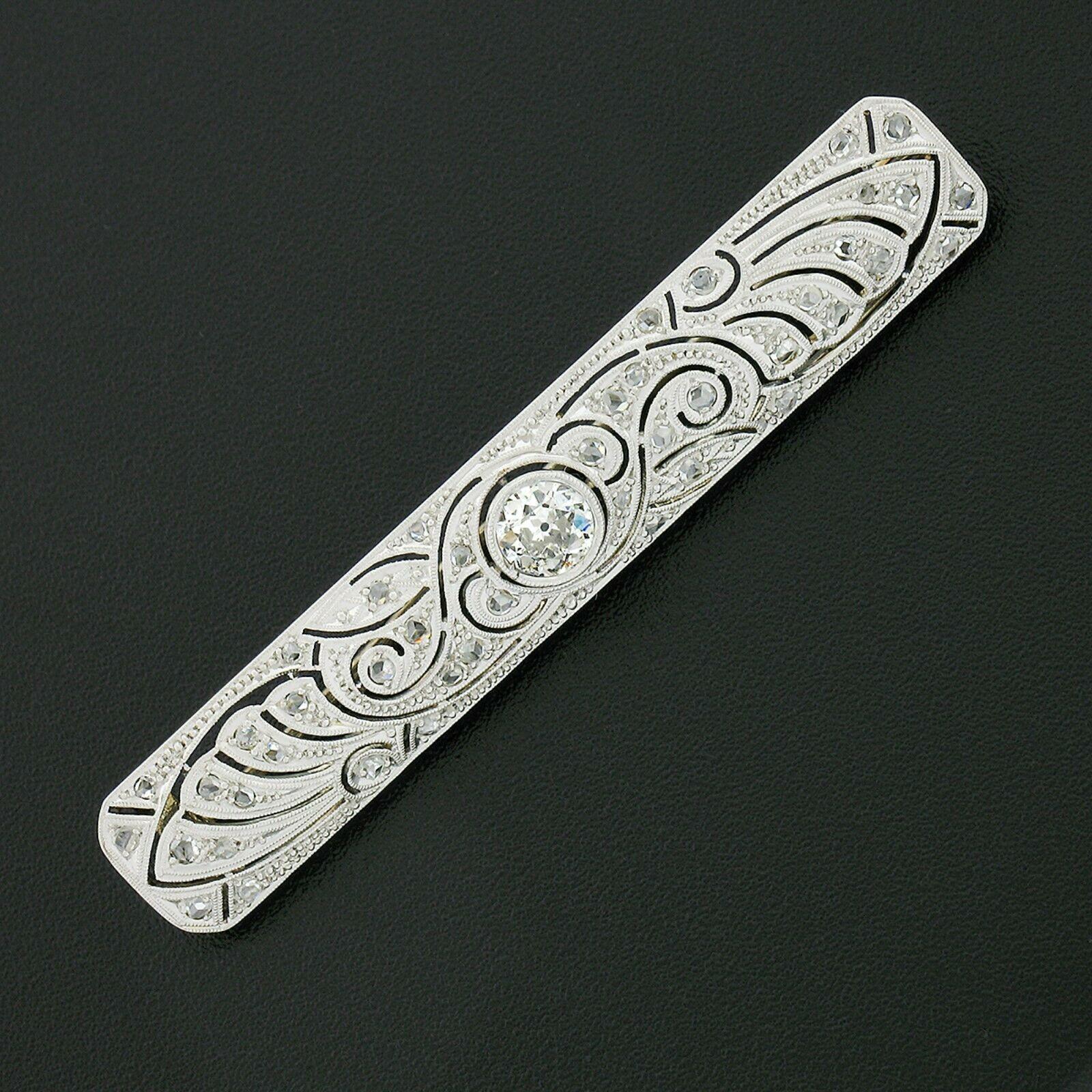 This stunning antique bar pin was crafted from solid 18k white gold during the Belle Epoque period and features a long rectangular shape set with fine diamonds throughout. The center of the brooch displays a breathtaking old European cut diamond
