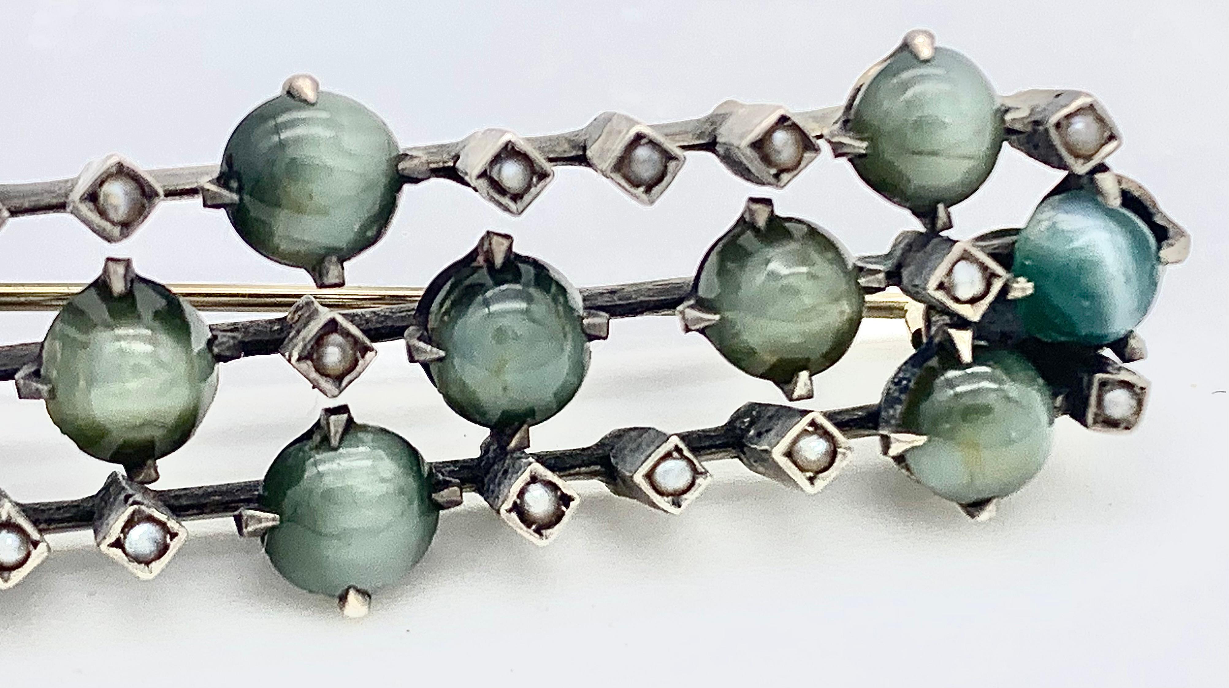 This delicate and charming brooch was made around 1885. It is designed as a series of quatrefoils made each with crysoberyll cats eye cabochon. The colour ranges from lighter green  to a green with turquoise. The three quatrefoils, each with a