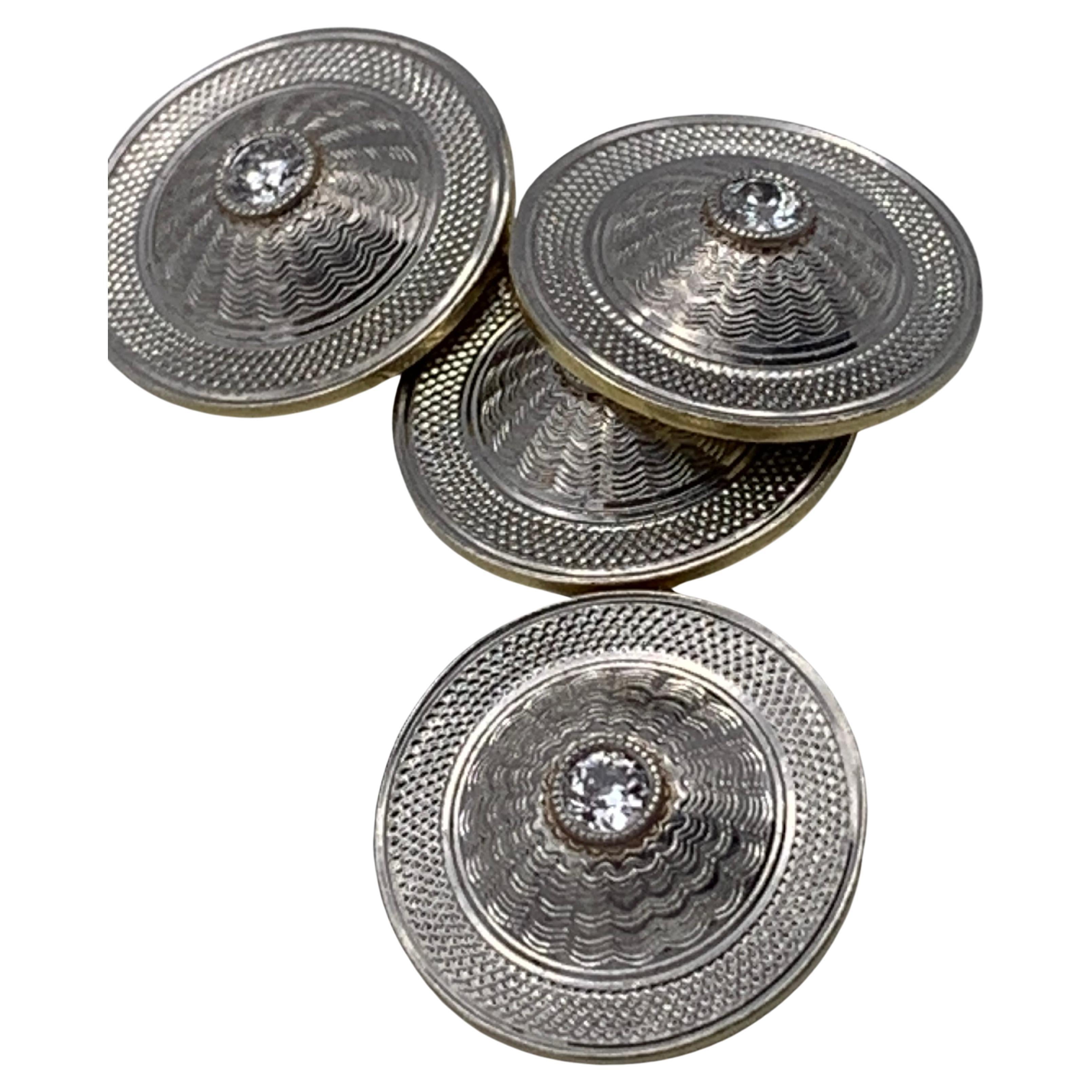 Ces élégants boutons de manchette en forme de dôme ont été réalisés vers 1910 en platine doublé d'or 14 carats. Chaque maillon est décoré de deux motifs différents tournés à la machine. Au centre de chaque bouton de manchette, un diamant de taille