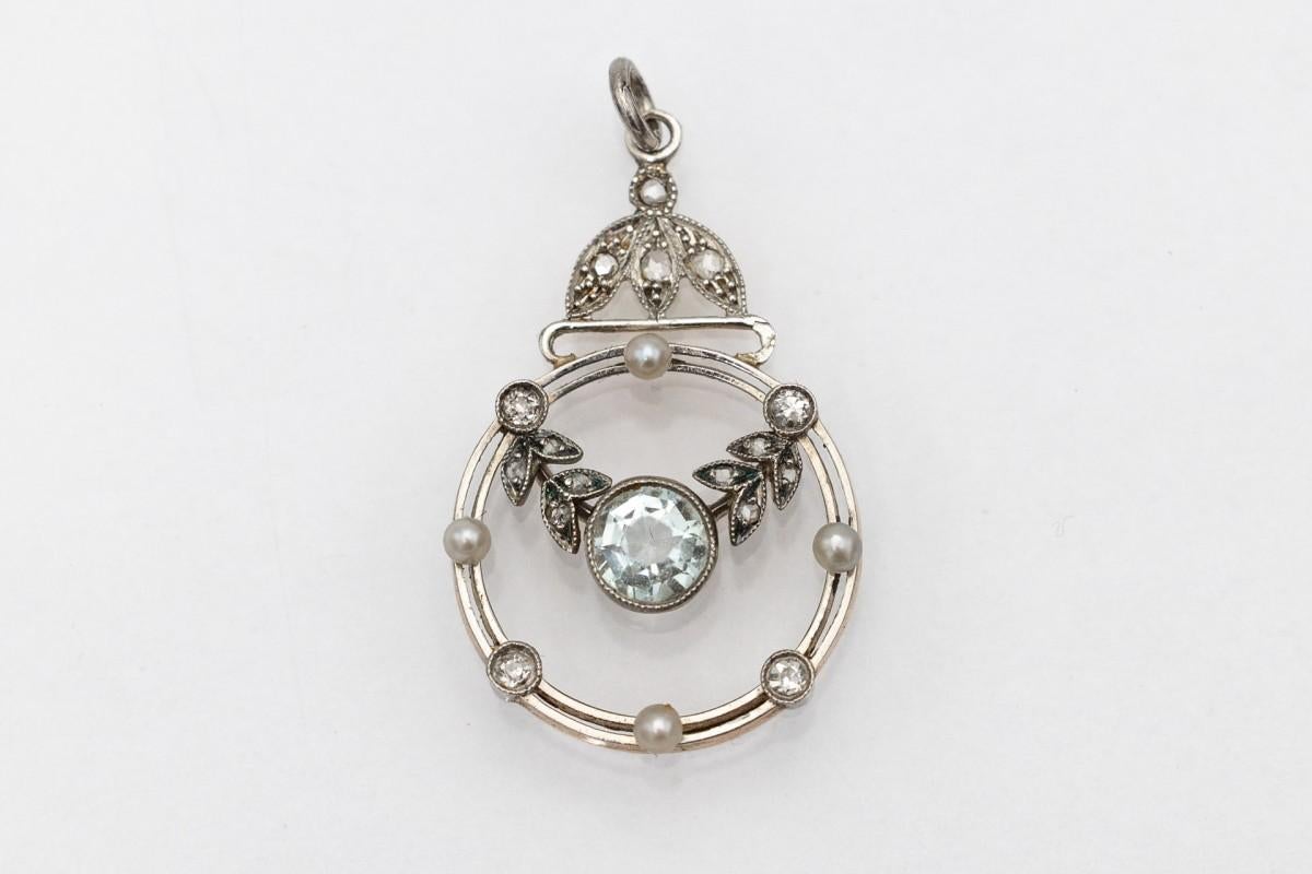A beautiful, antique pendant decorated with 16 diamonds, 4 cultured pearls and a round, faceted aquamarine weighing 0.45 ct.

Aquamarine is a precious stone with a blue or blue-green color, whose name comes from Latin and means 
