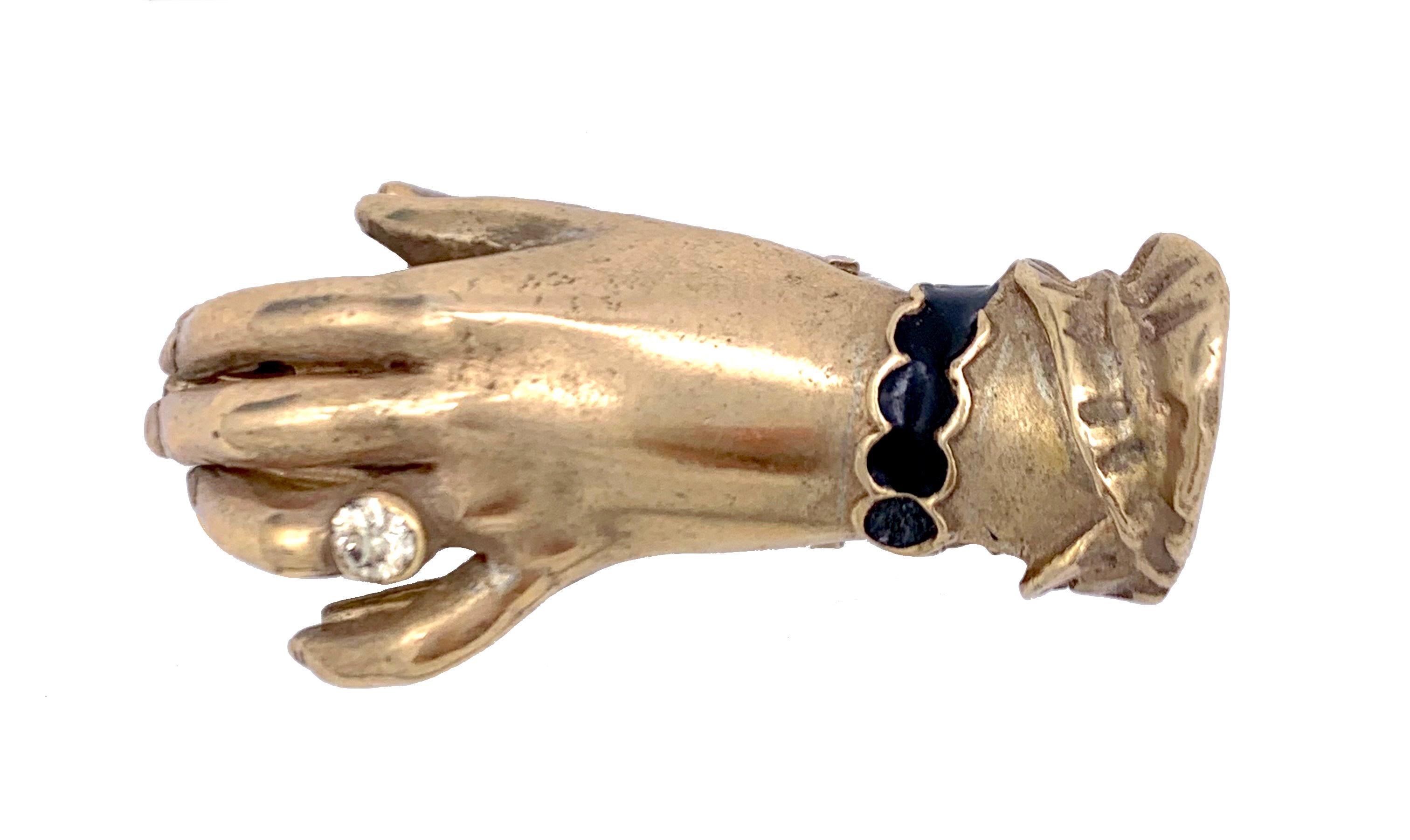 Ce magnifique trombone en forme de main est fabriqué en argent et porte la mention 800. La main porte une bague avec un véritable diamant et un bracelet émaillé. 
