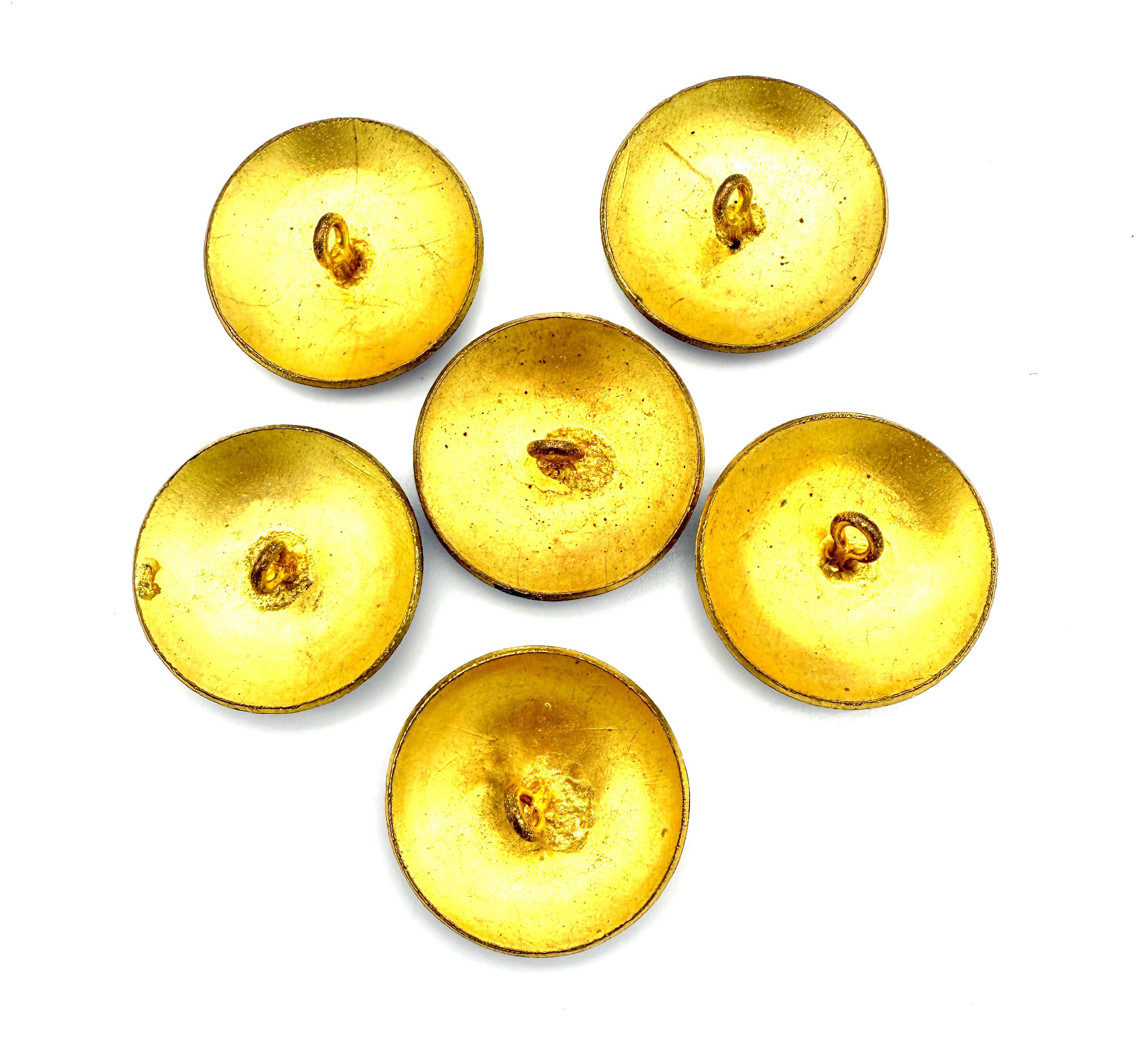 This set of six buttons was created towards the end of the 19th century. The buttons are made out of brass and are decorated with dark rose coloured guilloché enamel In between two opaque white circles.
Inside the immer circle the buttons are