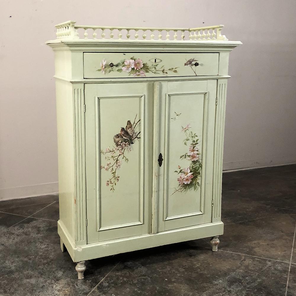 Antique hand painted cabinet is a delightful example of Belle Époque English charm featuring a superlative architecture and its original hand-painted finish embellished with an original work of art for a truly unique effect! Surprisingly spacious