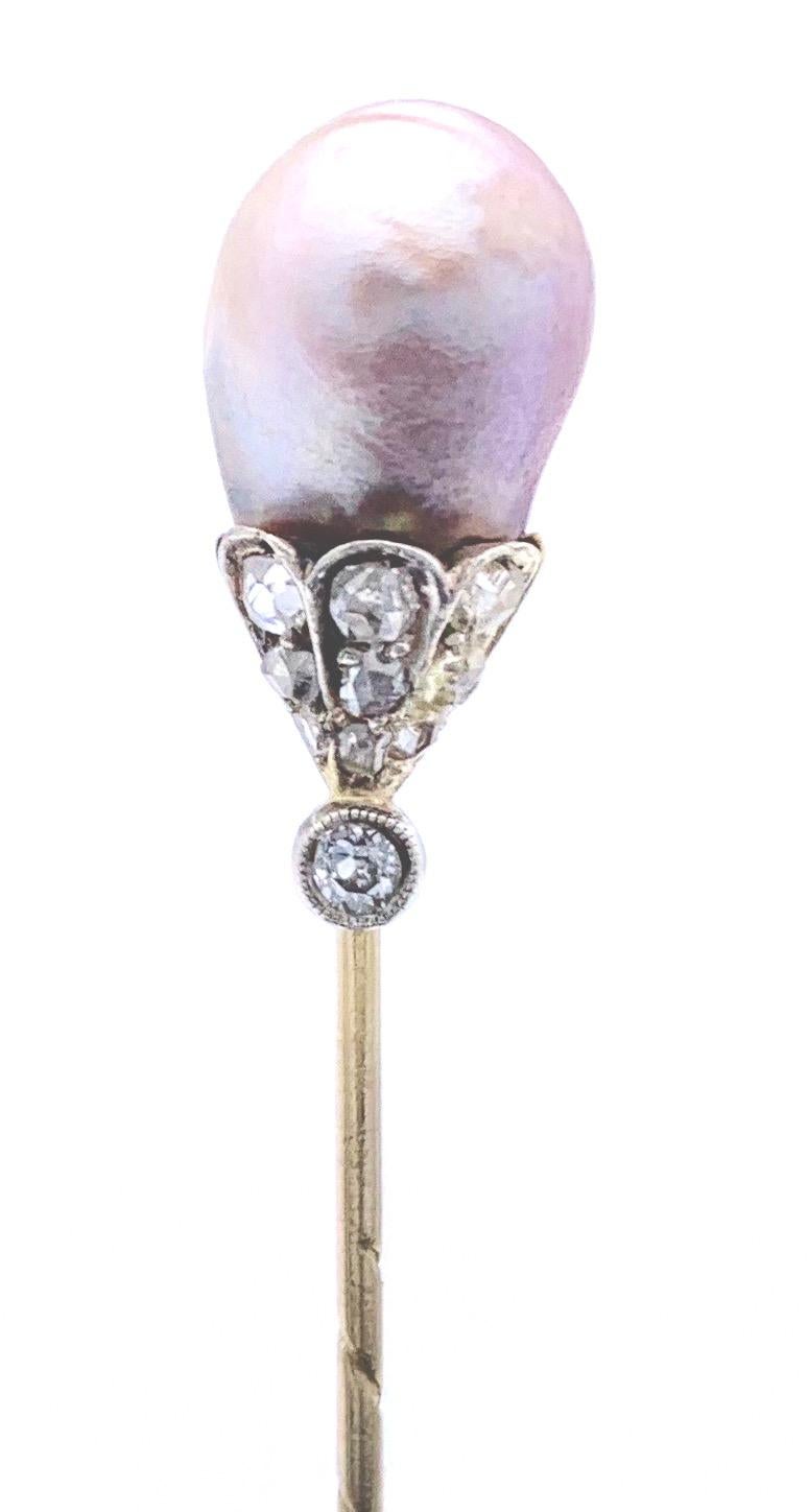 Wonderful intense pink natural orientpearl mounted as a gold stick pin. The pearl is mounted in a golden
calyx set with a larger diamond mounted in a mille grain platinum setting. 
