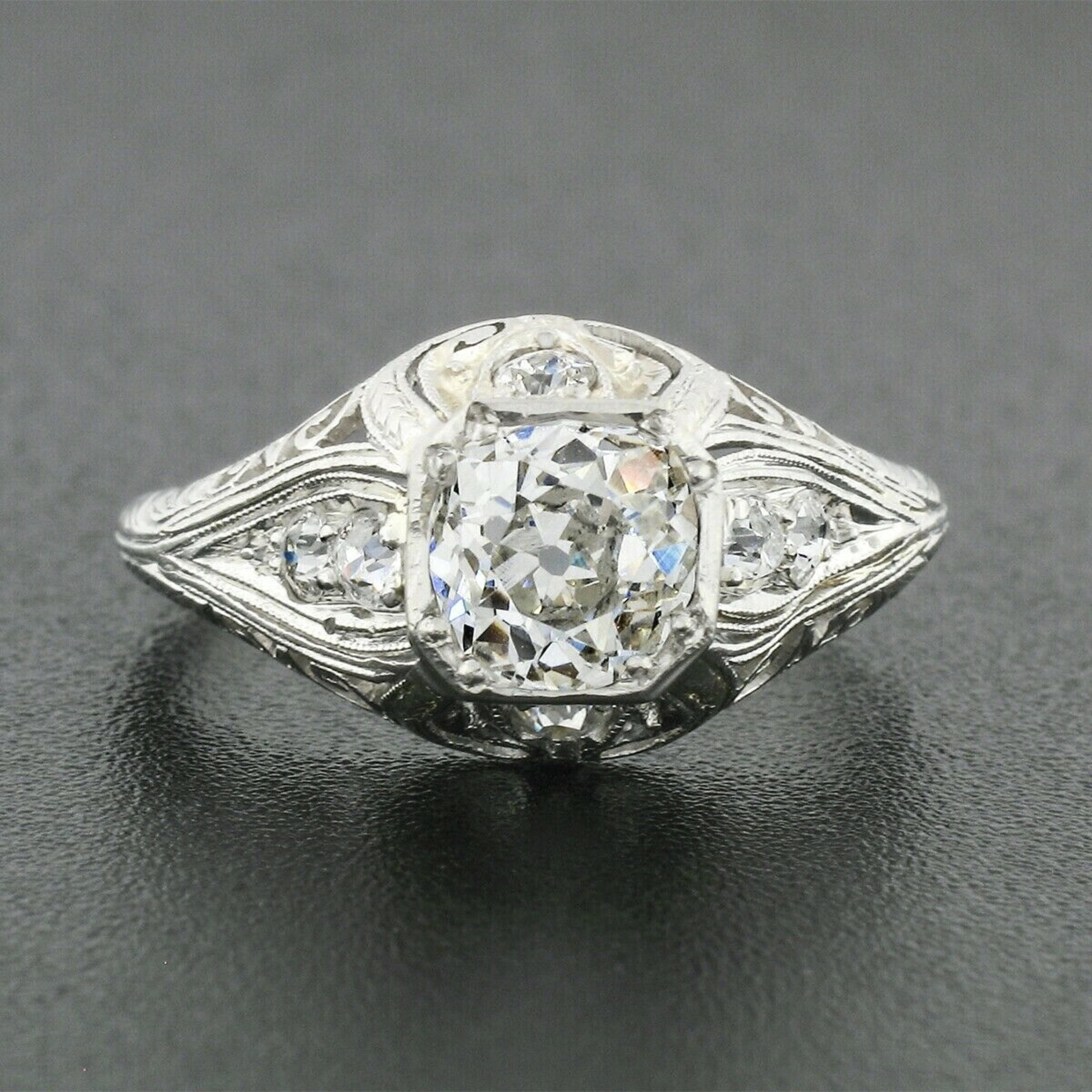 This incredible antique diamond engagement ring from the belle époque period features the finest and most beautiful milgrain etching technique, hand engraving and filigree designs that all remain intact and in perfect condition. The ring features an