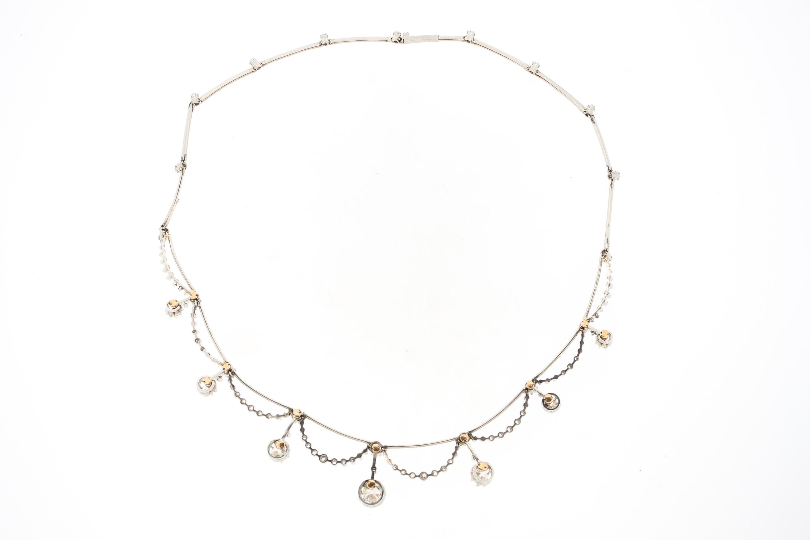Un très joli collier ancien Belle Époque en diamants datant d'environ 1910. Ce collier a des sections de platine en forme de couteau qui suspendent des demi-lunes sécrétées de diamants et une frange de pendentifs en diamants. Le collier fait le tour