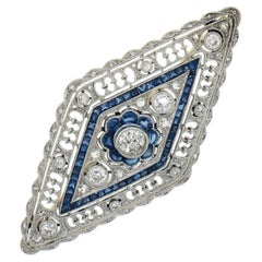 Antiguo broche de platino de la Belle Epoque con zafiro y diamantes en milgrain