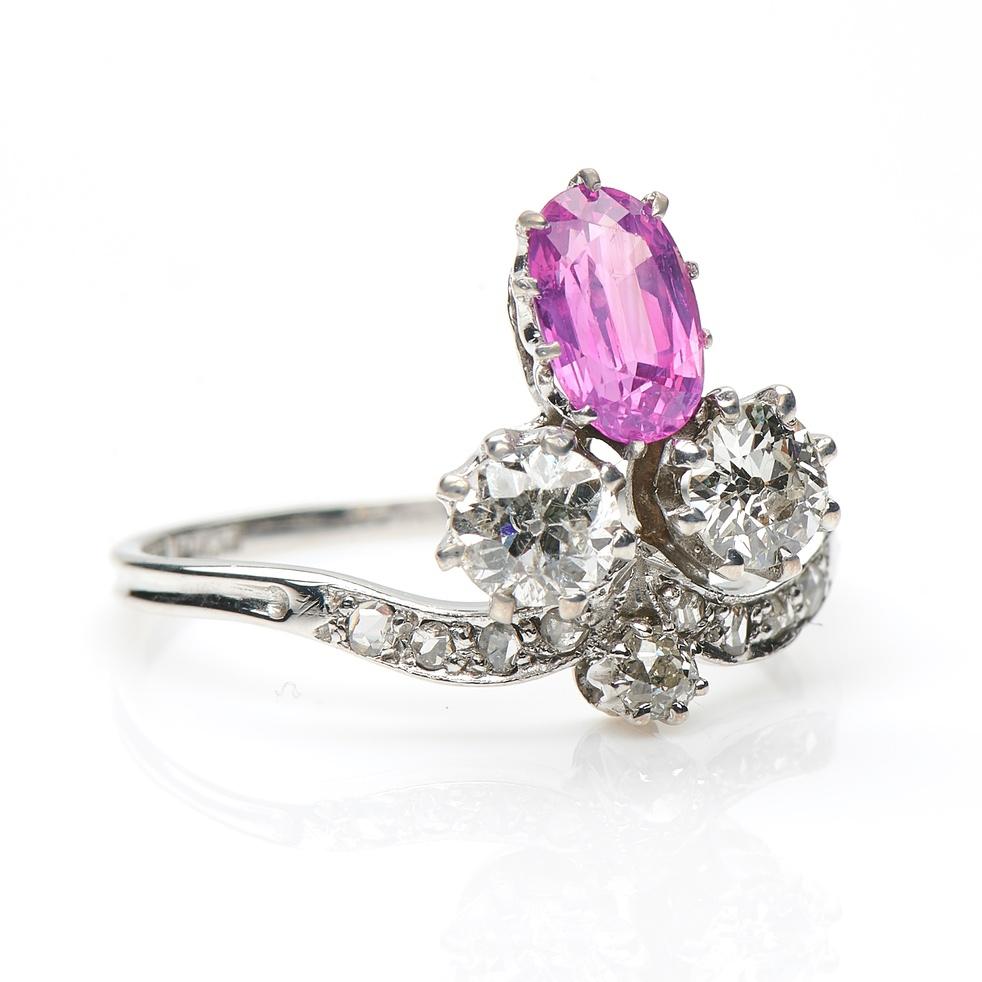 Art Nouveau, rare pink sapphire and diamond trefoil ring, circa 1900. Set to centre a natural  oval pink sapphire flanked by two old-cut diamonds with further diamond downward scrolled shoulders. The trefoil design looks incredibly elegant on the