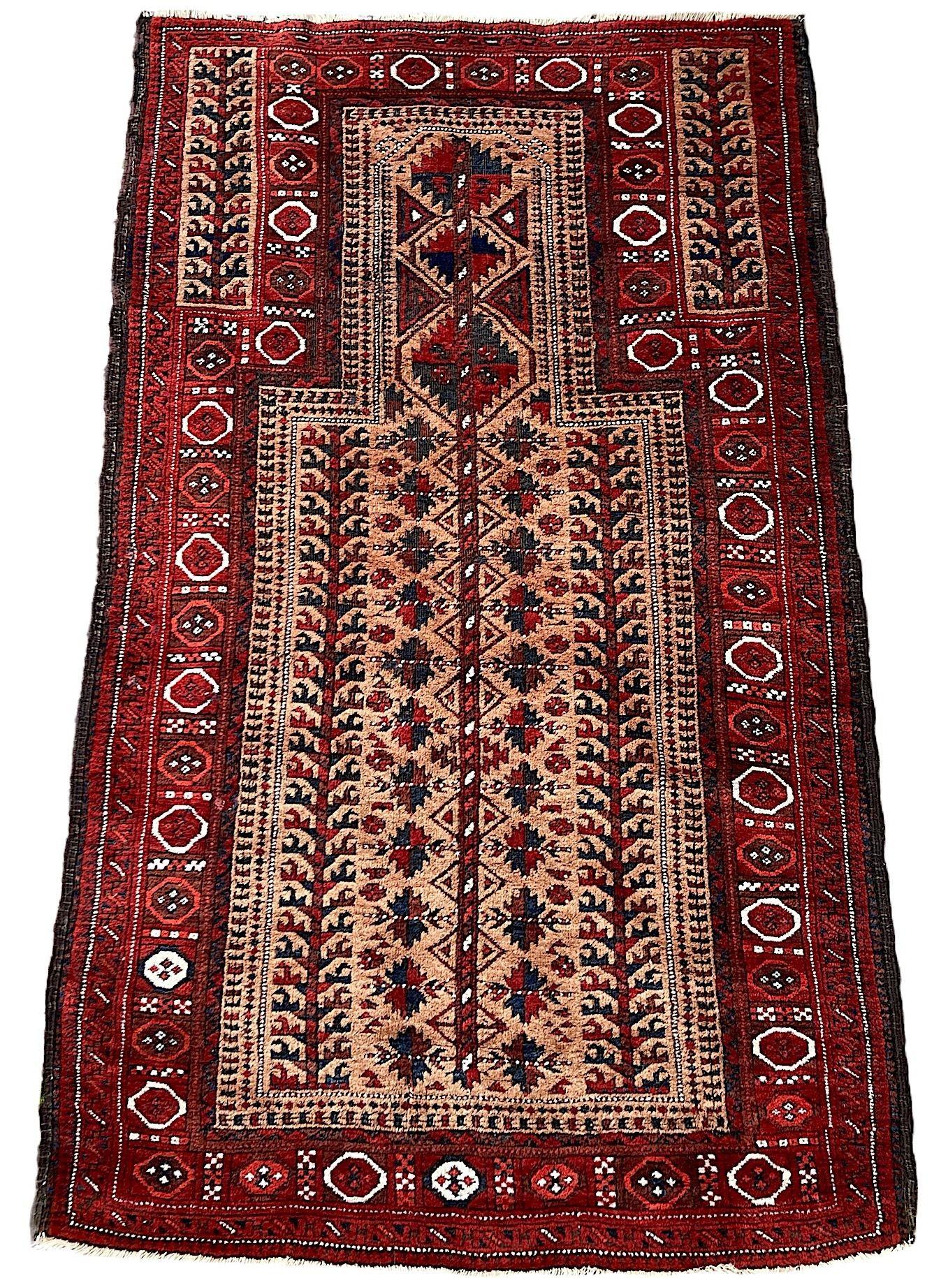 A wonderful antique tribal rug, hand woven by the nomadic Belouch tribe circa 1900. The rug features a classic prayer rug design with stylised trees and flowers on a camel coloured field. Finely woven with soft, lustrous wool and great secondary