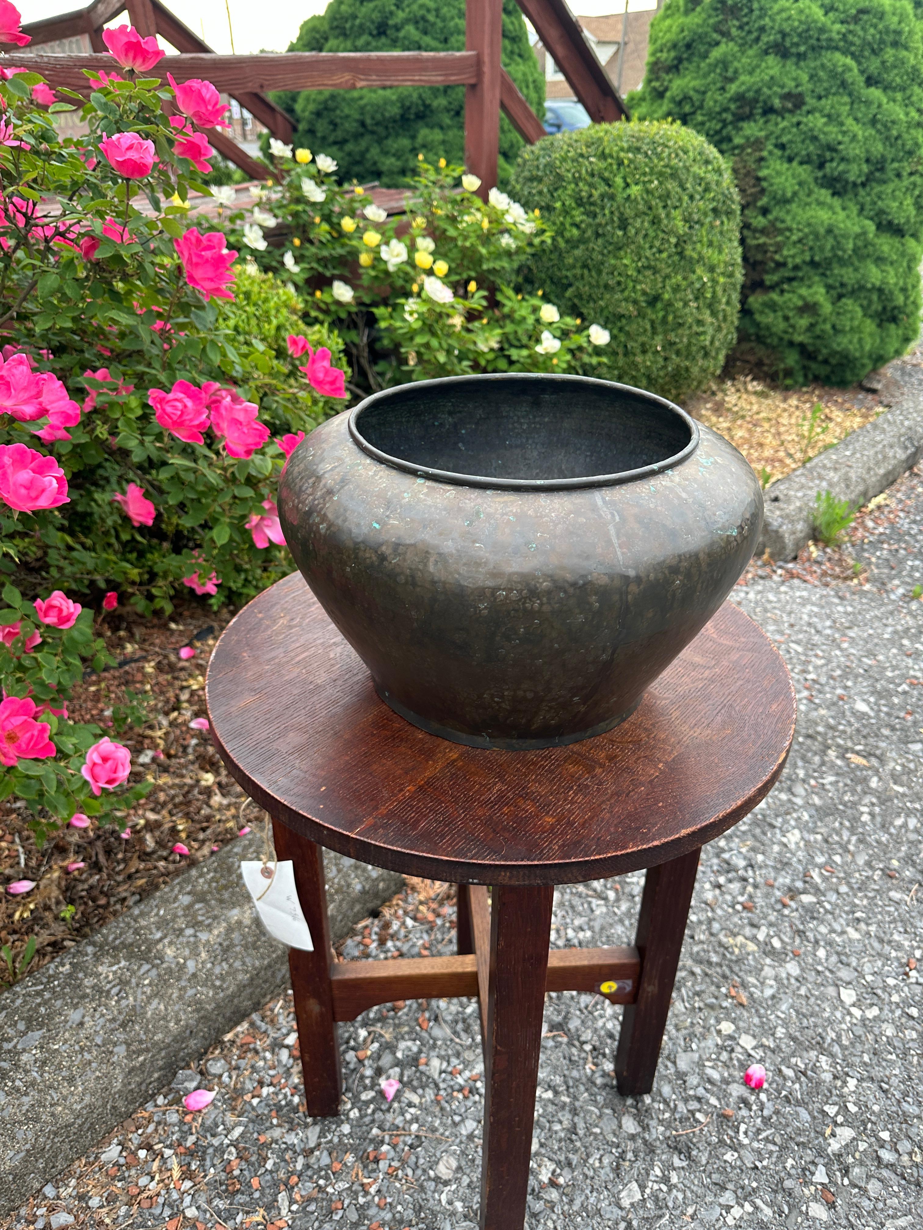 THIS IS AN ANTIQUE  ' benedict studios' COPPER HAND HAMMERED VASE/ JARDINIER FROM THE EARLY 1900SIN GOOD SHAPE AND WITH ORIGINAL PATINA, NO DAMAGE.
SIZE
H 9.5
W 16 INC
TOP OPENING 10 INCHES