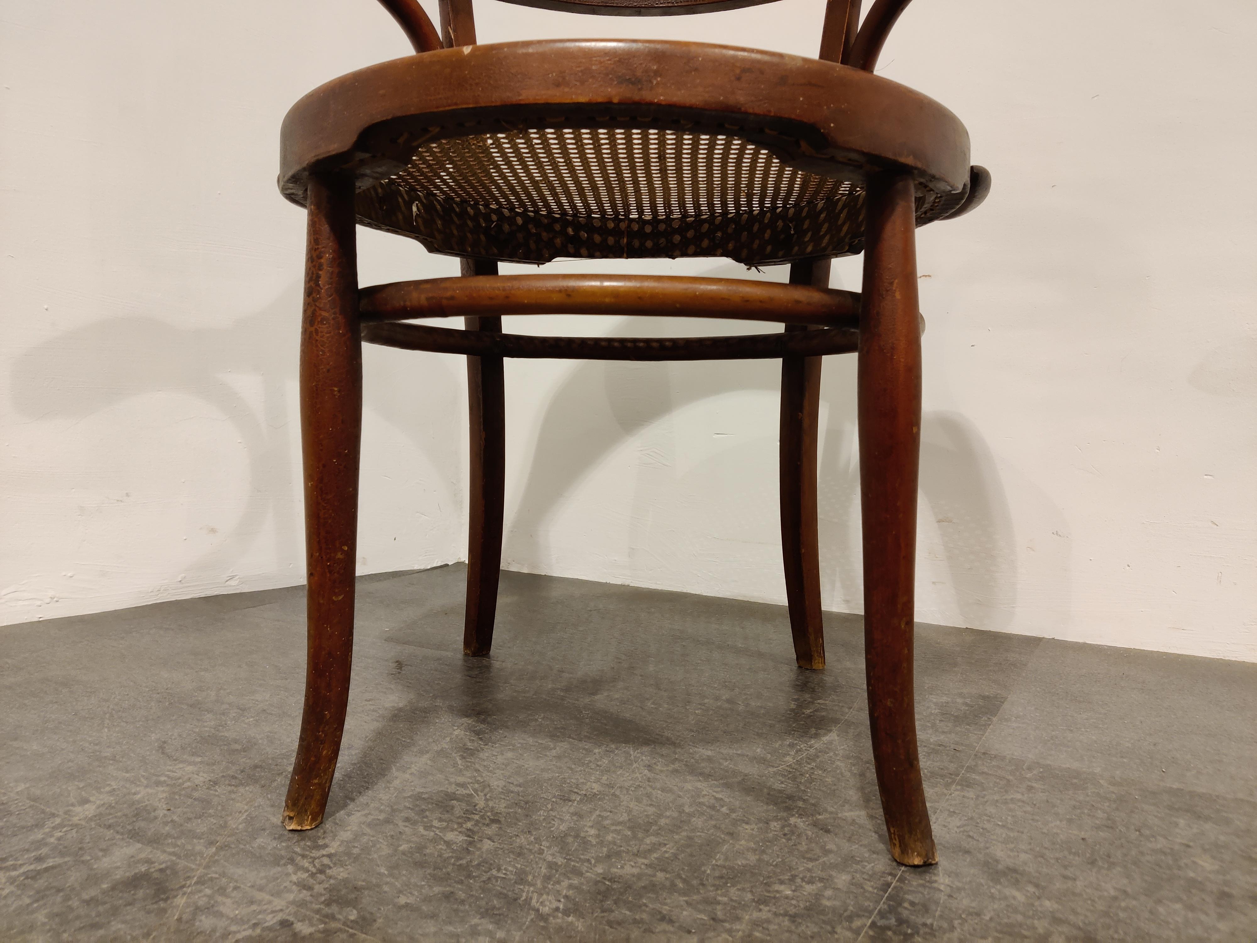 Fauteuil de salle à manger ou chaise bistro en bois courbé brun foncé.

Dans le style de Thonet avec une sangle originale 

Nous la datons du début des années 1950.

Bon état avec usure normale liée à l'âge. 

Dimensions :
Hauteur