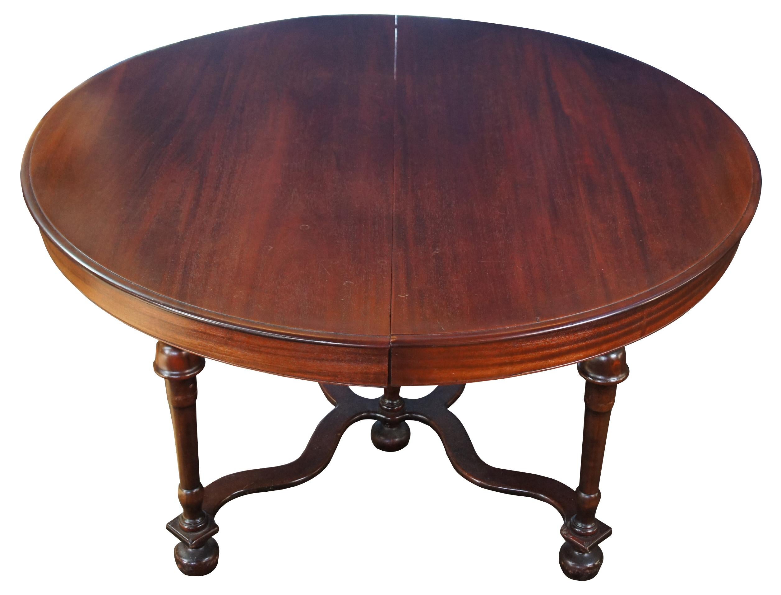 Antique Berkey & Gay Knoleworth William & Mary dining table. Made of mahogany featuring round form that extends to oval with five turned legs connected by serpentine stretchers and bun feet.. The William and Mary style was a transitional style