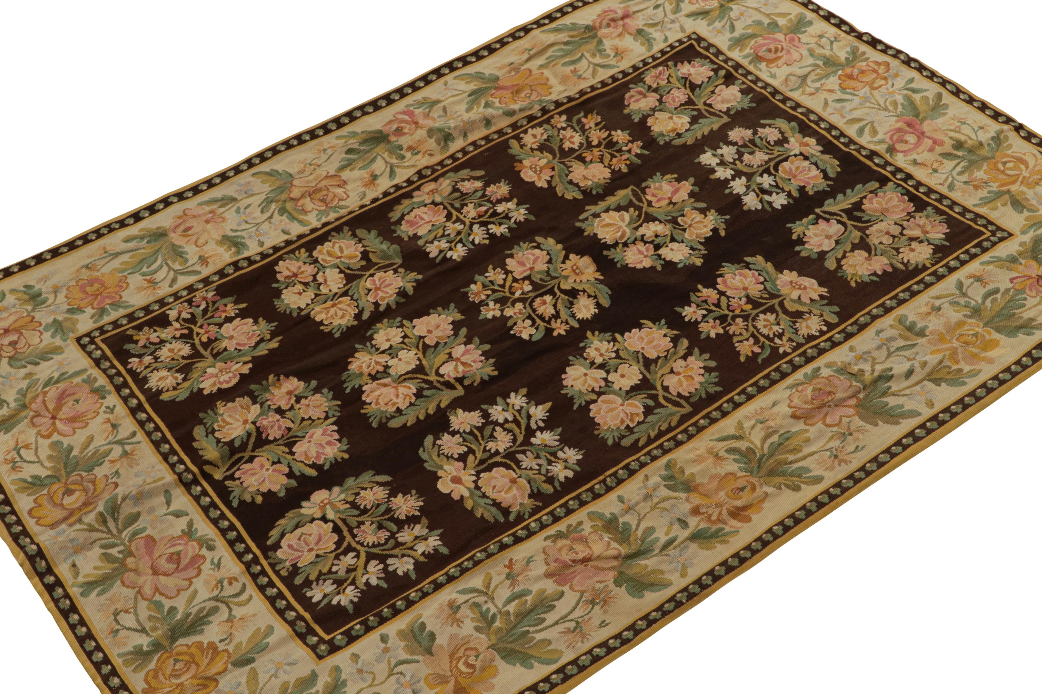 Handwoven in wool, this rare 5x8 antique Bessarabian kilim rug is believed to originate from Romania circa 1850-1860. Its design features a wide beige border around a rich chocolate brown field, with floral patterns in soft colors. 

On the design: