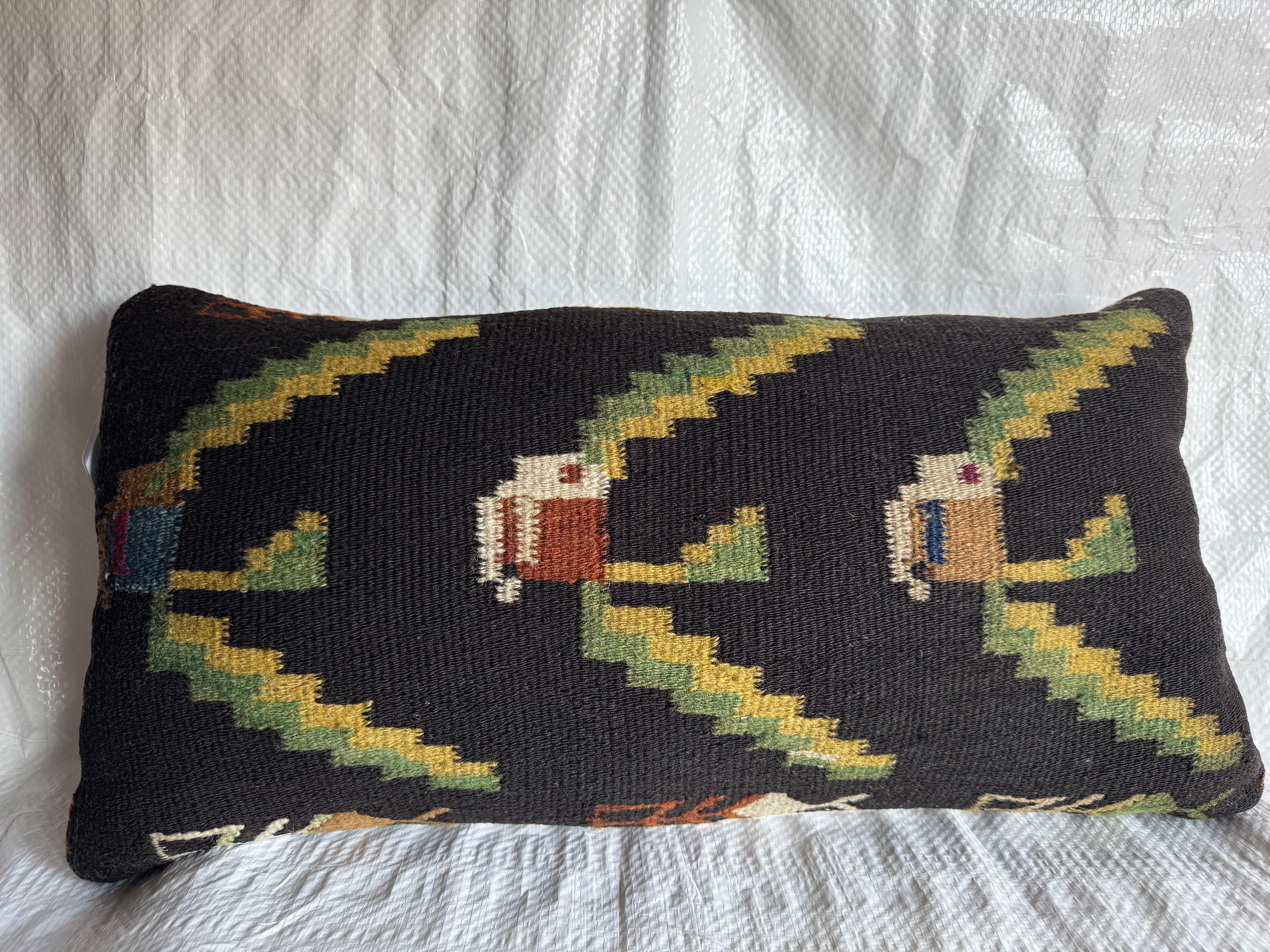 A rare 19th-century Bessarabian pillow handwoven circa 1880, featuring a striking geometric and floral motif in earthy tones of green, gold, ivory, and rust over a deep black ground. The intricate kilim weave reflects the distinctive craftsmanship