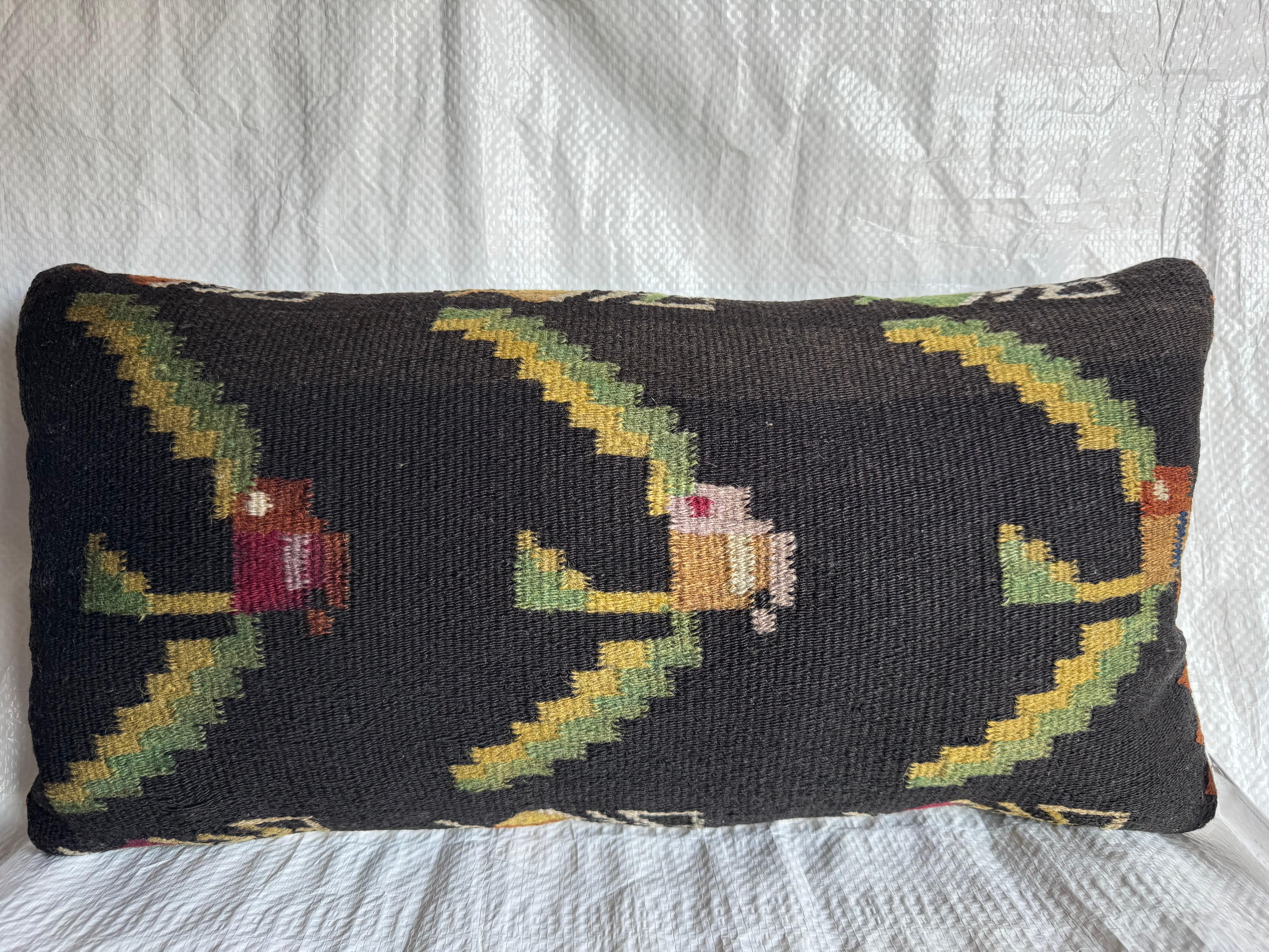 A rare late 19th-century Bessarabian pillow handwoven in wool with striking geometric zigzag motifs and stylized folk figures on a deep black field. The intricate pattern reflects the traditional craftsmanship of Moldovan artisans, known for their