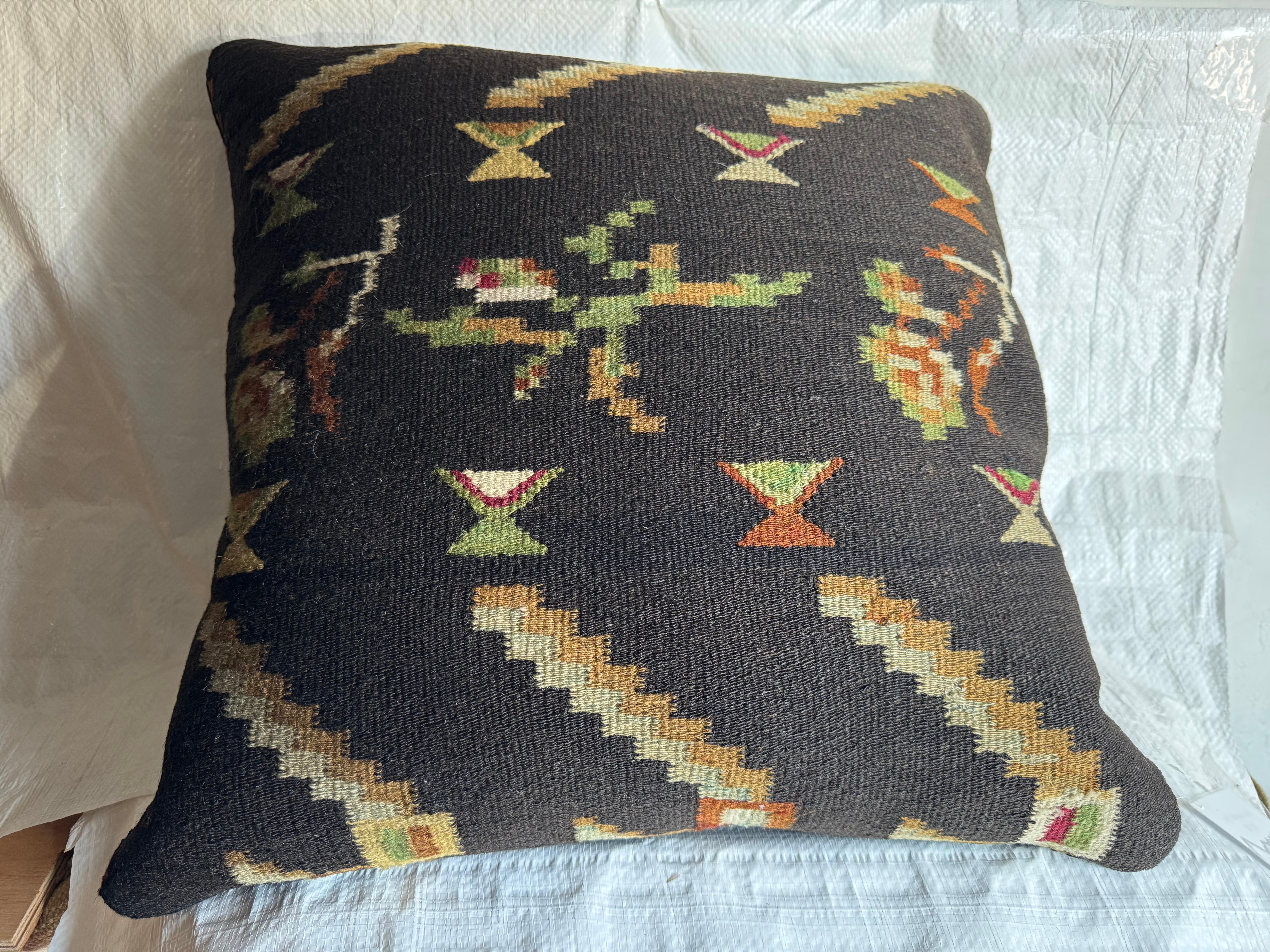 Questo cuscino bessarabico del XIX secolo, unico nel suo genere, è stato tessuto a mano in Moldavia utilizzando le tradizionali tecniche kilim a trama piatta. Il design presenta zigzag a gradini, motivi floreali astratti e forme a clessidra