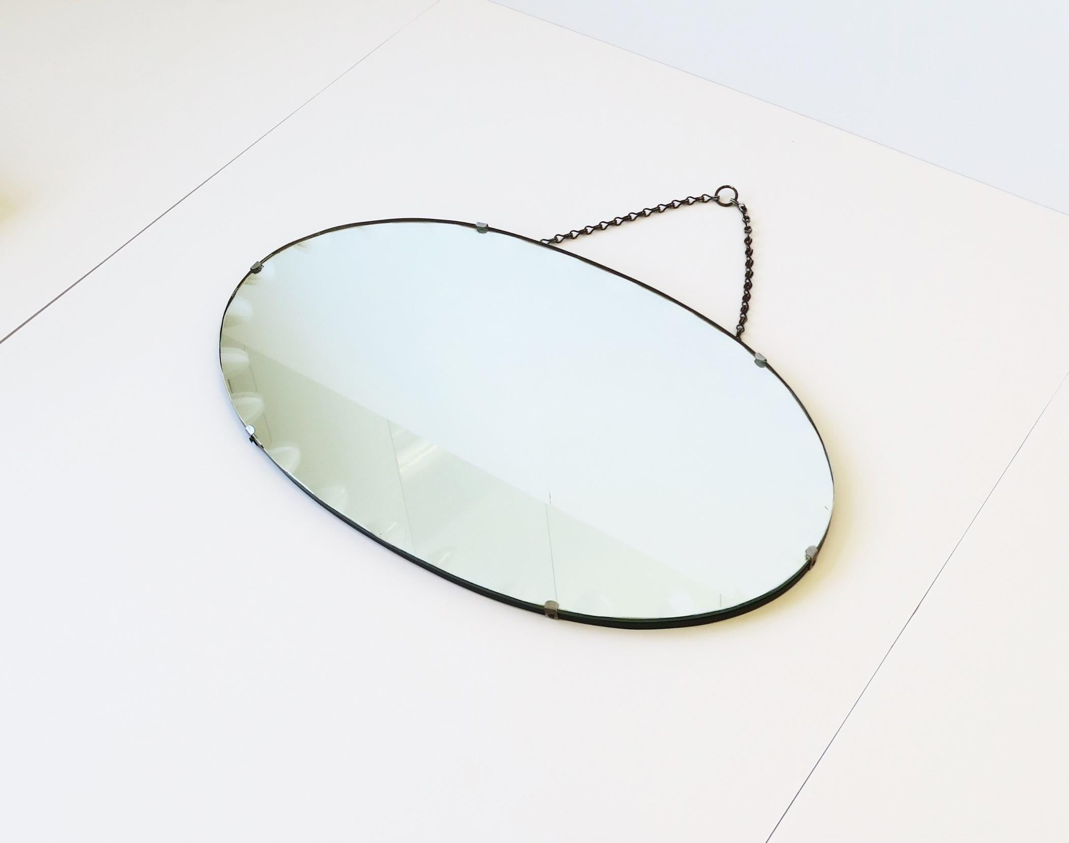A very beautiful antique wall or vanity mirror with a modern bevel design around, circa early 20th century. Piece is oval in shape featuring this modern bevel; A design I haven't seen before. This bevel design can be seen best in images 3, 5, and 7.