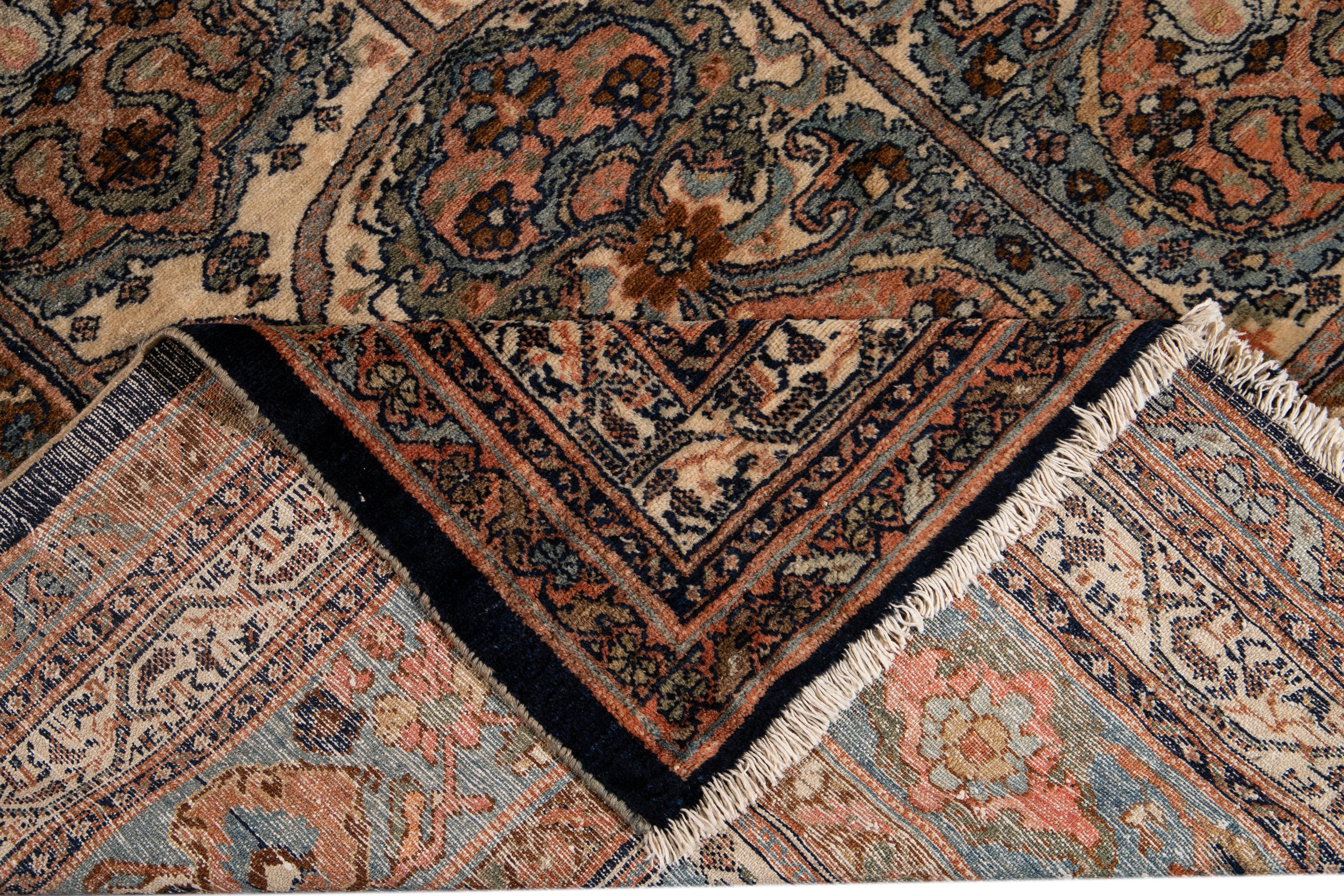 Beautiful antique Bibikabad hand-knotted wool rug with a beige field. This piece has a designed frame with peach, green, and blue accent colors on a gorgeous all-over classic garden floral design.

This rug measures 11'6