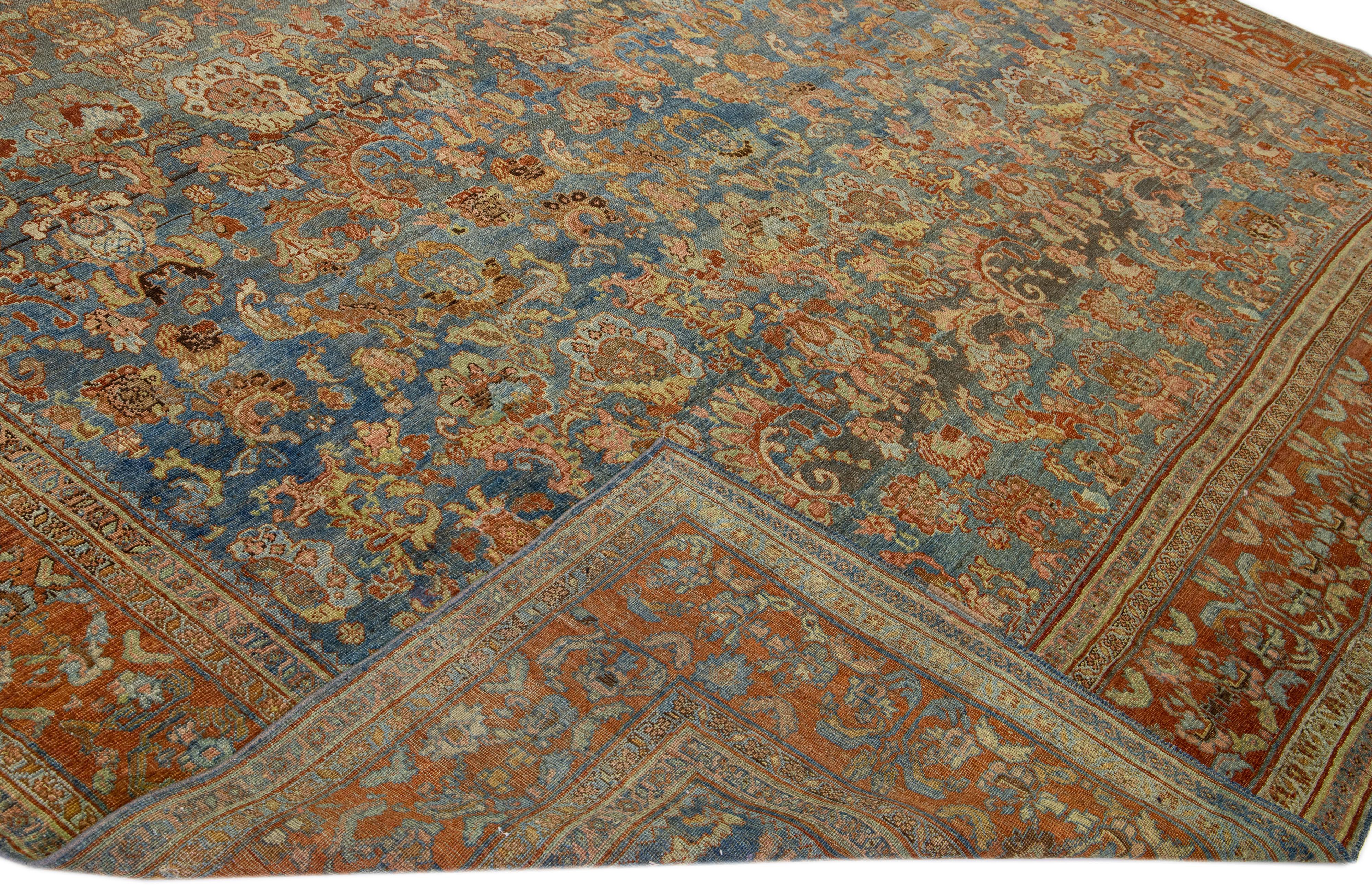 Beautiful antique Bidjar hand-knotted wool rug with a blue field. This Bidjar rug has a rusted frame and multicolor accents in a gorgeous all-over traditional floral design.

This rug measures 12'3