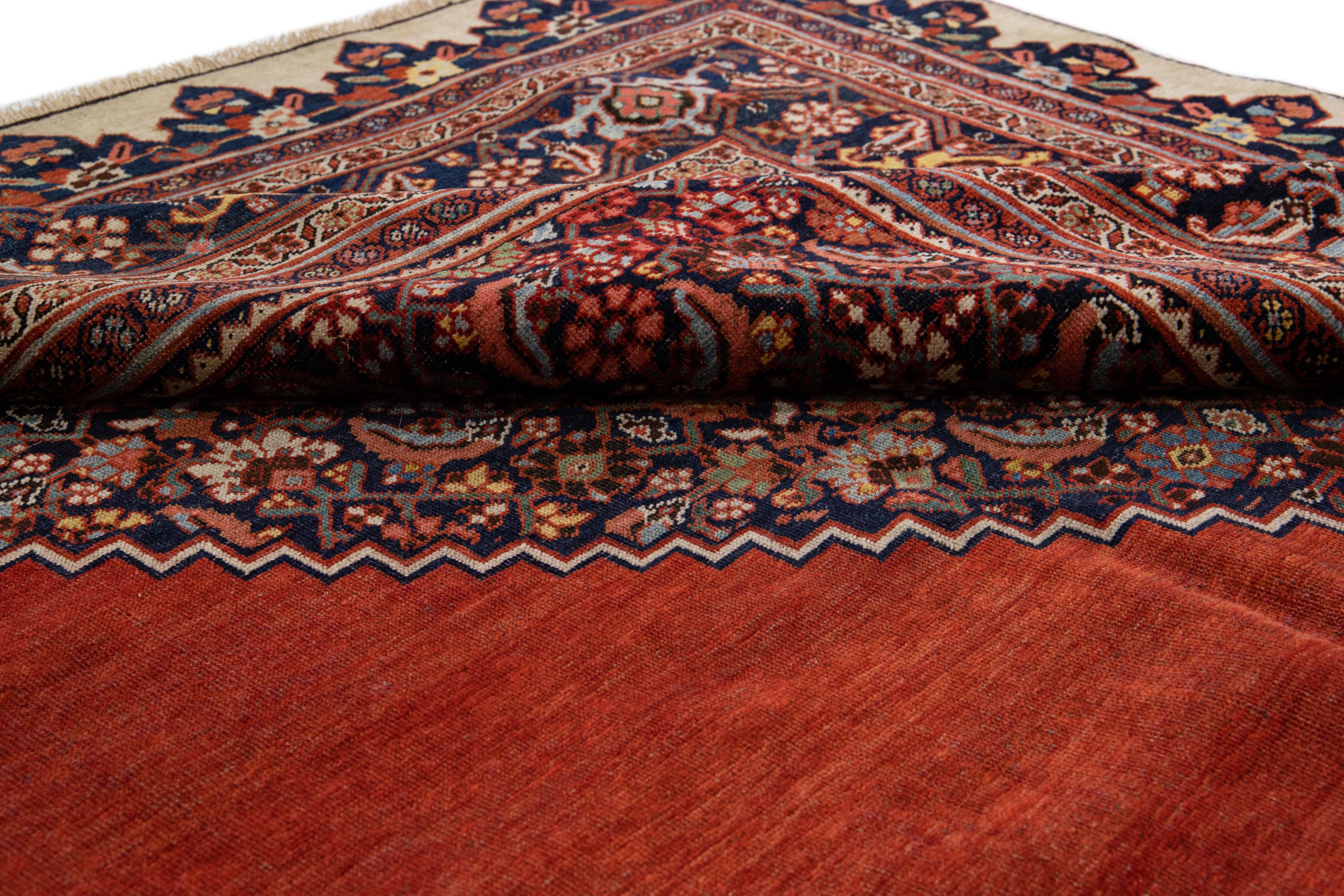 Magnifique tapis ancien Bidjar en laine nouée à la main avec un champ rouge. Ce tapis persan présente des accents multicolores dans un motif central en médaillon.

Ce tapis mesure : 11'1