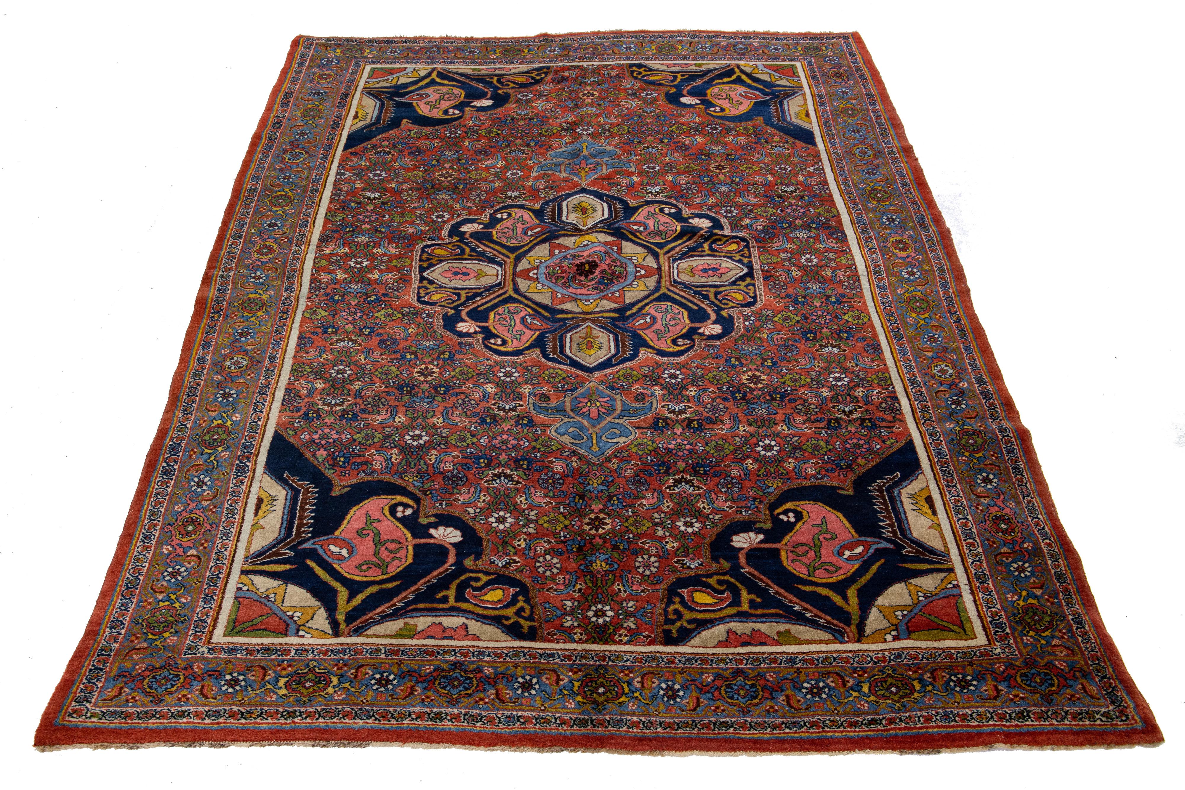 Beautiful antique Bidjar hand-knotted wool rug with a red color field. This Persian rug has a blue frame with multicolor accents in a gorgeous all-over traditional floral design.

This rug measures 7'5