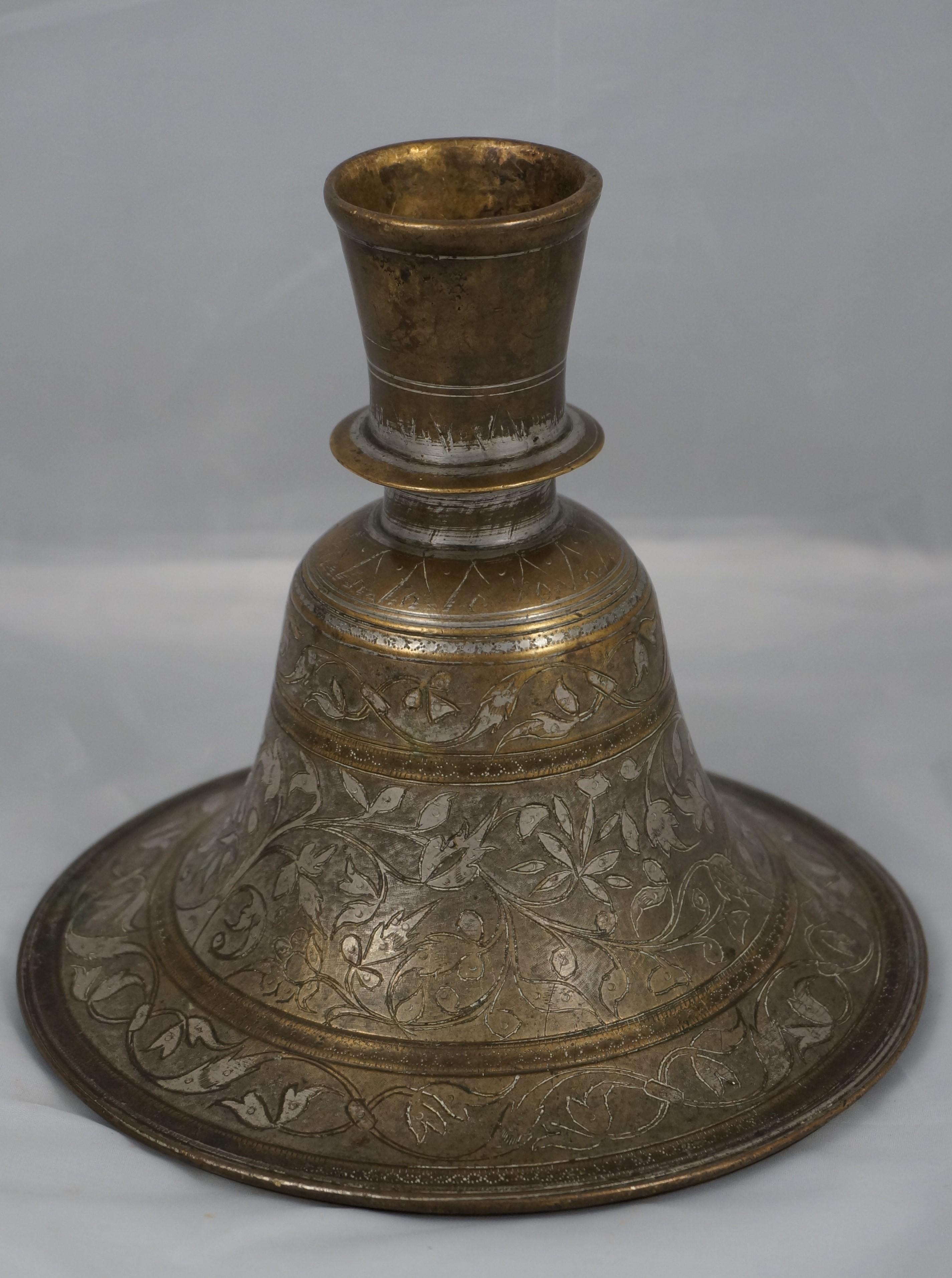 Indian Bidri Hookah Base, decorated with floral patterns and folliage.

India, Bidri ware, 19th century.

In fairly good condition, worn due to age (see images).

Dimensions: 16 cm. heigh, diameter 17.2 cm.