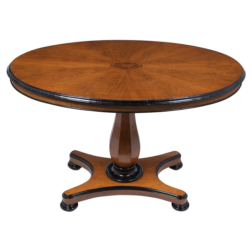 A remarkable antique oval center table handcrafted from walnut wood finished a light walnut color with ebonized molding details and is in good condition. This eye-catching 1870's gueridon features an inlay design on the oval top that rests on a