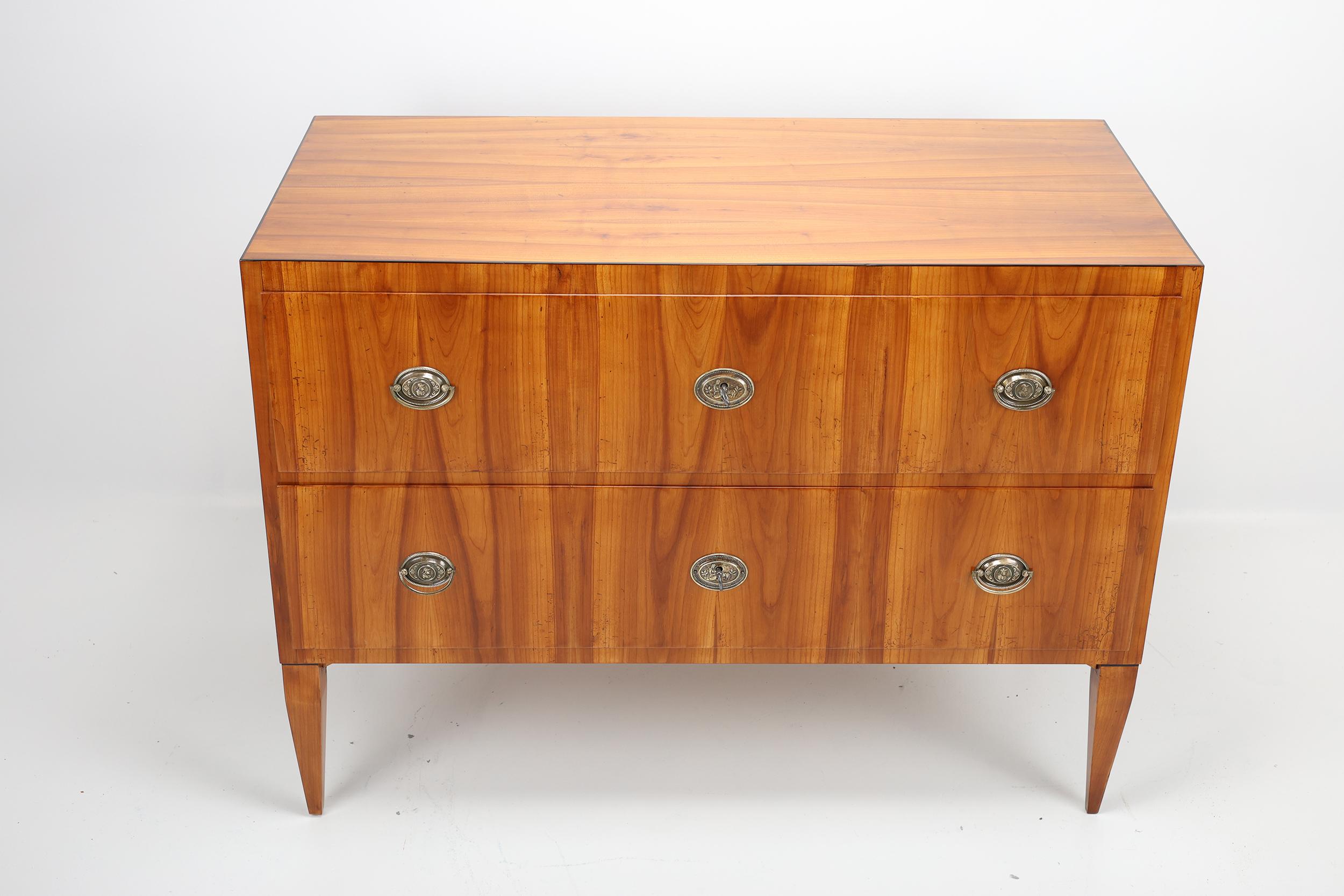 Antico cassettone Biedermeier in Wood

Questa squisita cassettiera Biedermeier, realizzata a mano tra il 1810 e il 1820, incarna l'eleganza e la semplicità dello stile Eleg e Biedermeier. Realizzato in legno di ciliegio di alta qualità, presenta