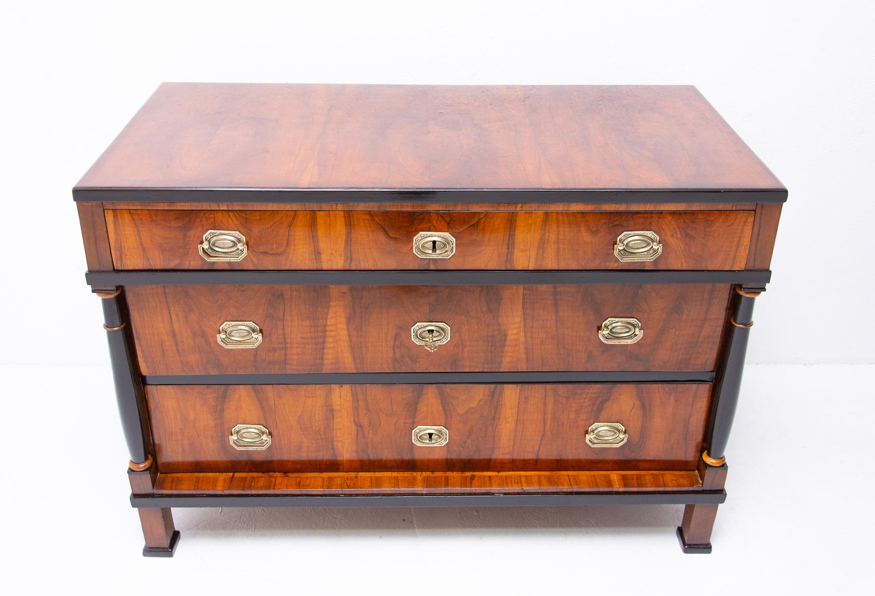 A chest of drawers from the Biedermeier period, made in the 1830s and featuring a walnut veneer and decorative motifs typical for this period. This bookcase has been professionally refurbished using shellac polish and remains fully functional in