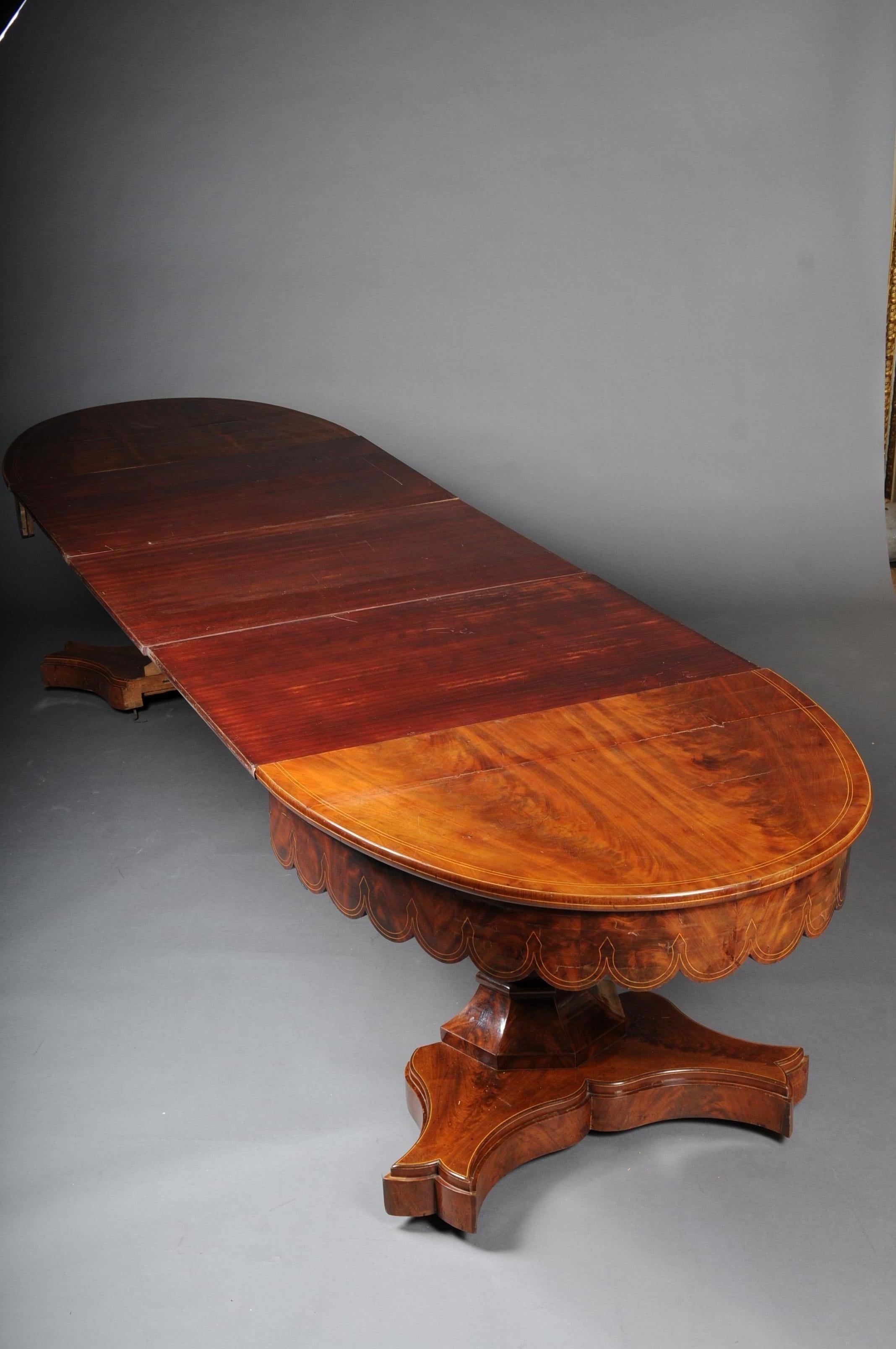 Antique Biedermeier dining table in mahogany from around 1820.

Solid wood veneered with mahogany. Extremely high-quality workmanship and extremely robust.

Scale-shaped frame with thread inlay work. Solid balustrade shaft spread out in X-shaped