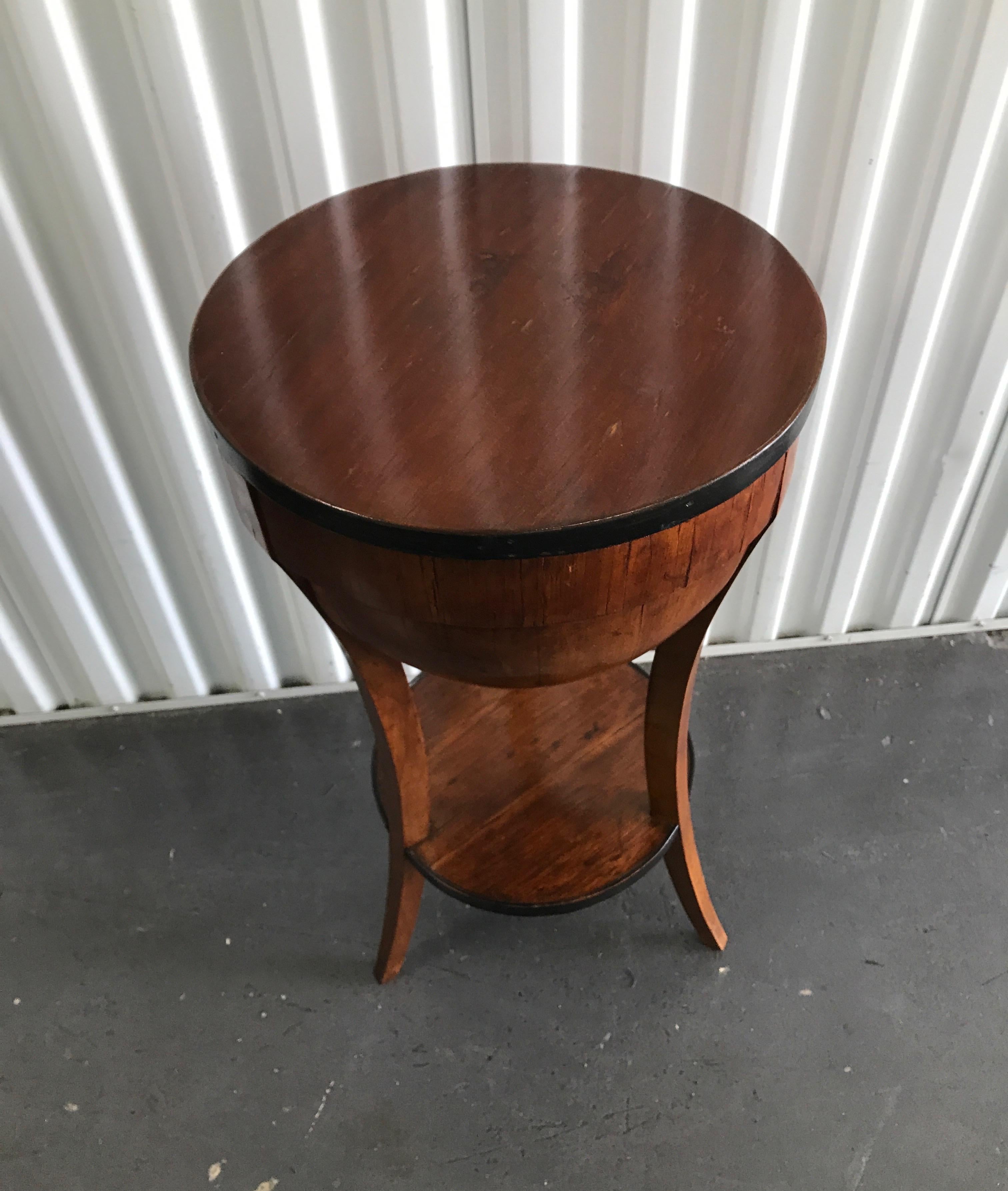 Round two tier antique sewing table. Top opens to reveal compartments, small drawer and pin cushion.