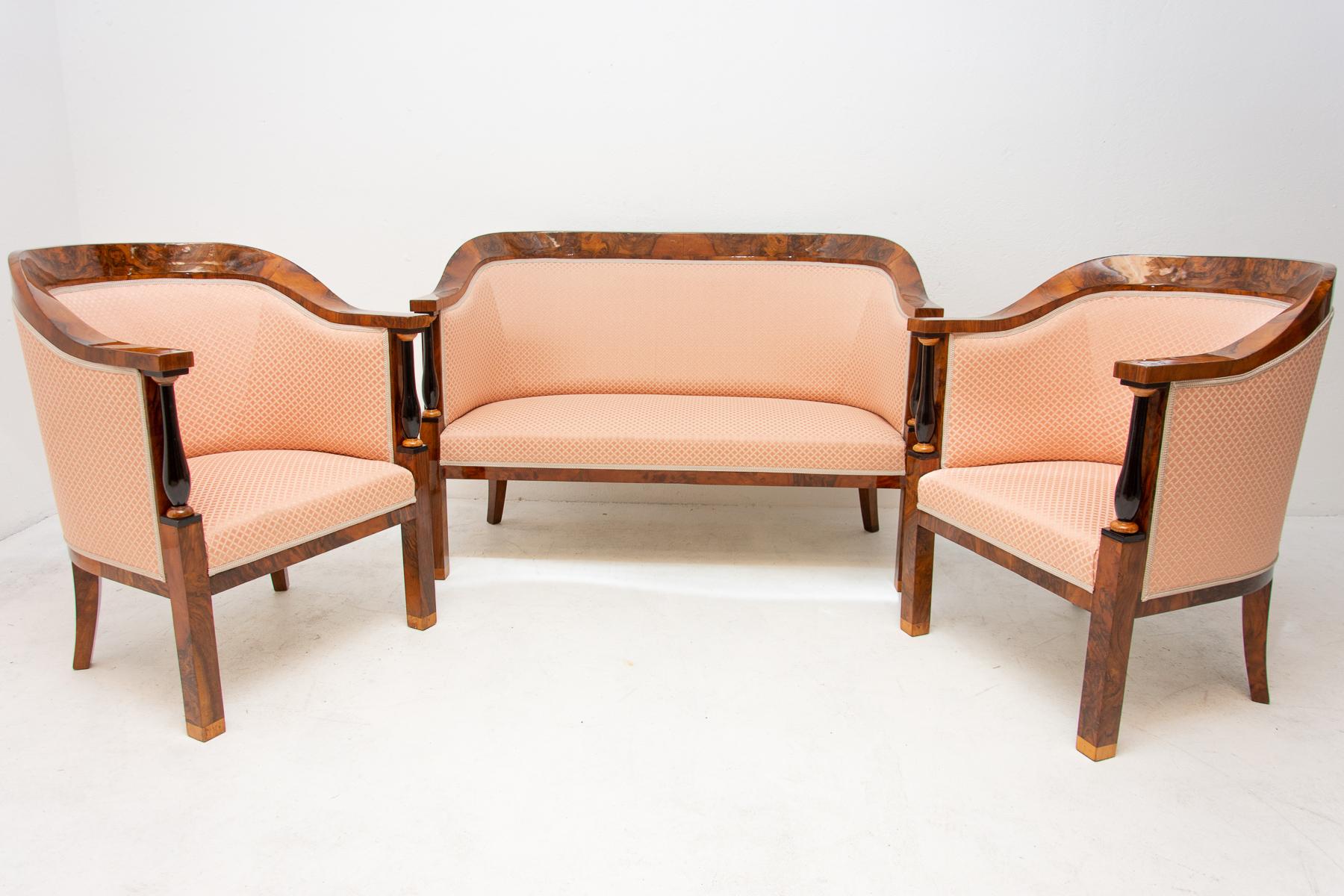 This seating group includes two armchairs and one sofa and it dates from the Biedermeier period. It was made circa 1830 in the former Austro-Hungarian Empire. The furniture is veneered with walnut veneer, new upholstery made in the original style.