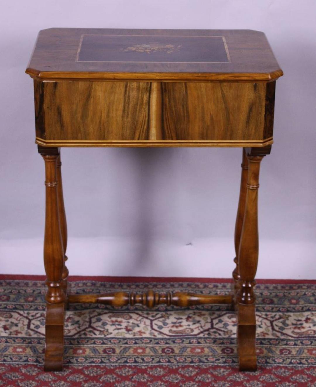Wonderful petite sewing table or end table with stunning marquetry works on the tabletop. The inlay works show a fruit-bowl as well as a large bird sitting next to it and are made of different colored fruitwoods like apple, cherry and pear. The