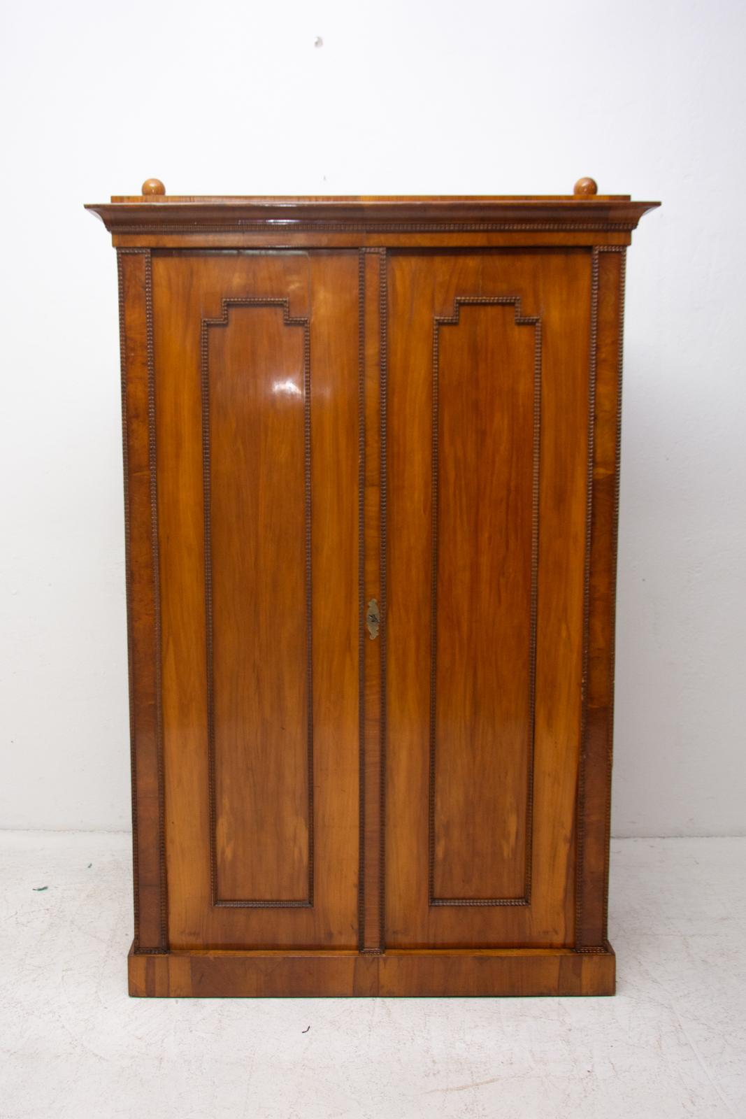 A shelf cabinet/ storage cabinet from the Biedermeier period, made in the 1830s and featuring a walnut veneer and decorative motifs typical for this period. This cabinet was professionally refurbished using shellac polish and remains fully