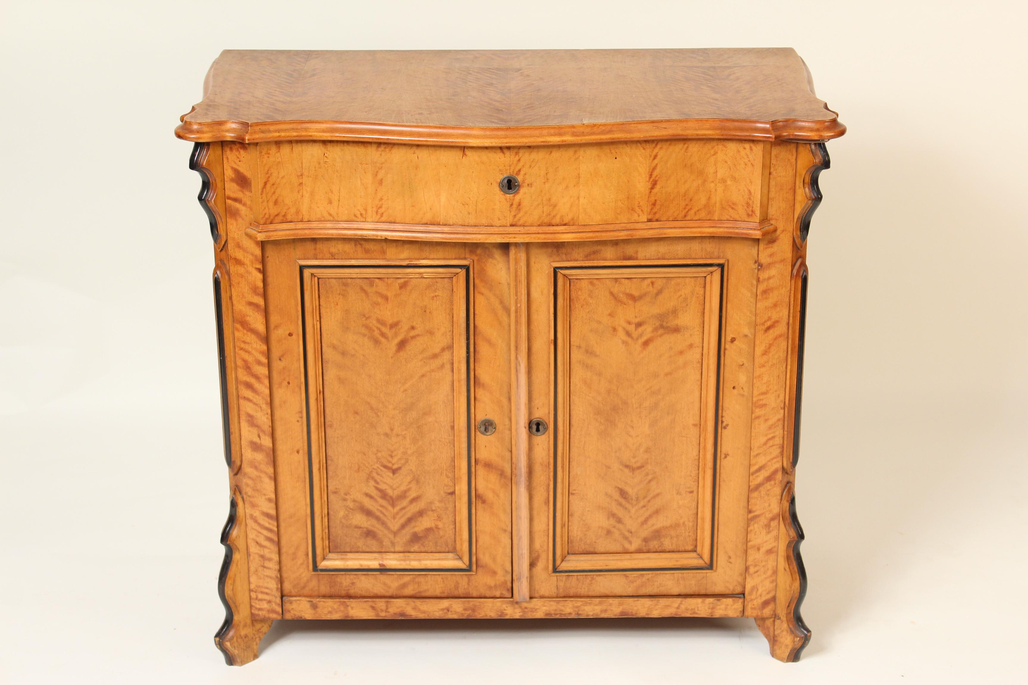 Antique Biedermeier style birch occasional cabinet with ebonized trim, circa 1900.