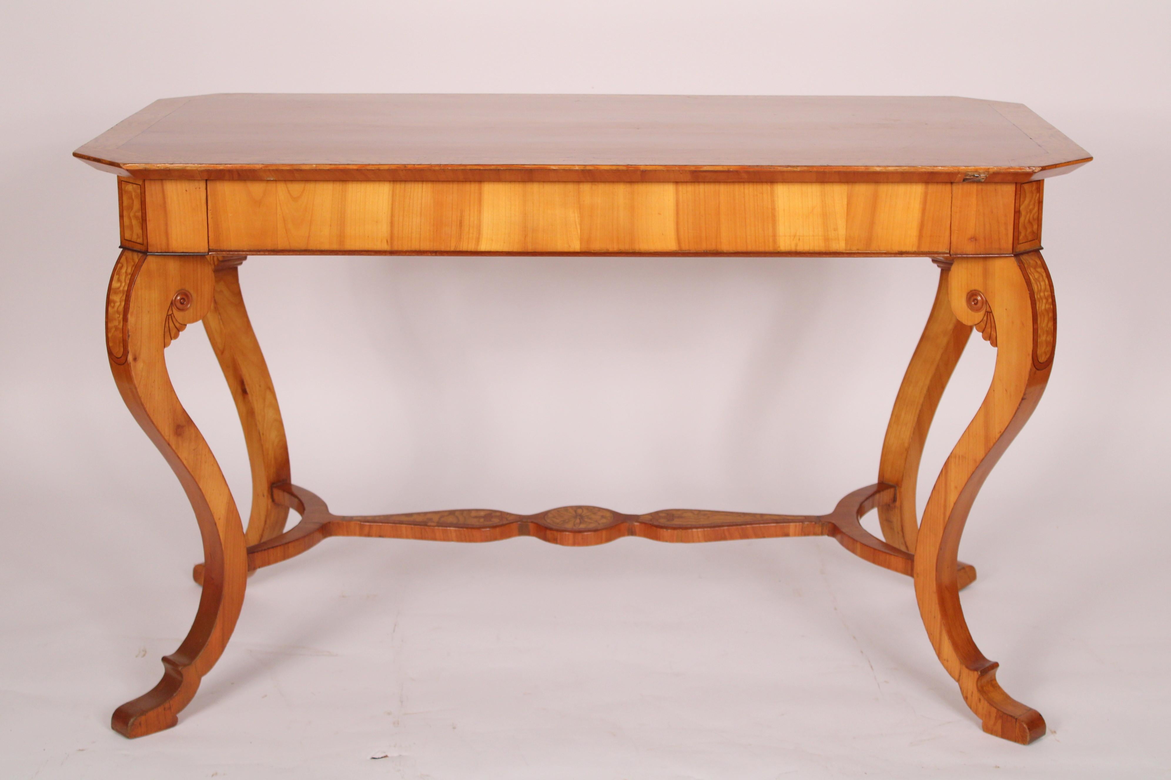 Antique Biedermeier style cherry wood and ash writing table, late 19th century. With a rectangular overhanging cherry wood top with canted corners and ash banding, a long frieze drawer, resting on 4 cabriole cherry wood legs with ash inlay, joined