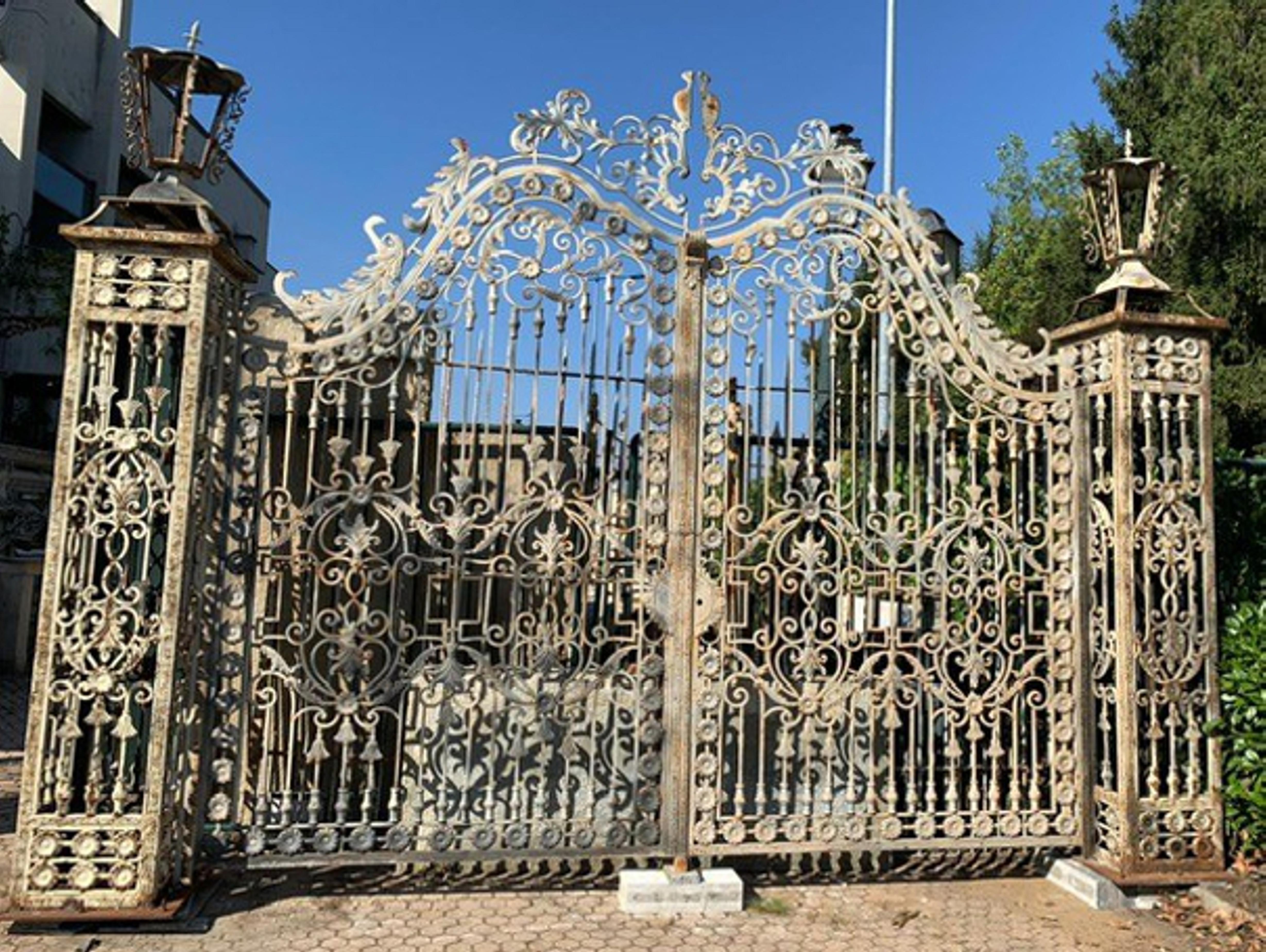 Ancient and large entrance gate in hand-made wrought iron, main entrance, majestic, sculpted and decorated, of important size and grandeur, richly decorated with flowers and various decorations, handmade in the late 19th century for a palace in