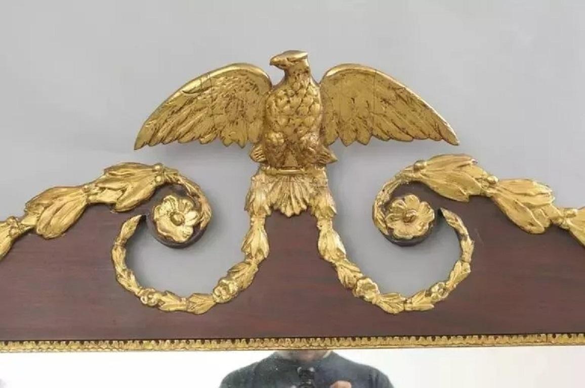 Miroir mural ancien à trois panneaux au-dessus de la cheminée, en acajou doré, de style Feder. Cette pièce présente un miroir de cheminée en acajou à trois panneaux orientés horizontalement, avec un fronton à volutes centré sur un fleuron d'aigle