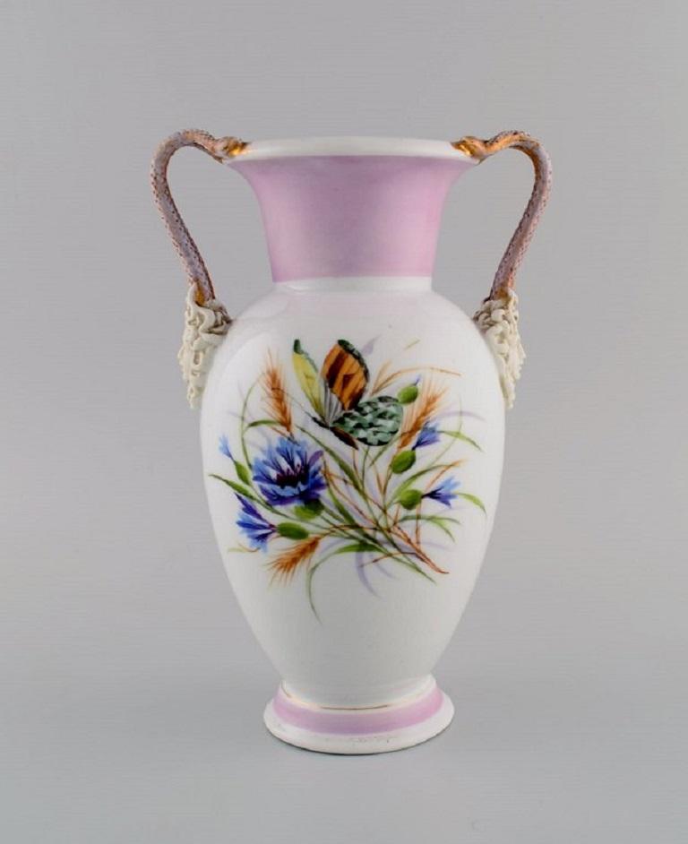 Antique Bing & Grøndahl porcelain vase with hand-painted butterflies and flowers. Handles modelled as snakes from Medusa's hair. 
1870s.
Measures: 24 x 15.5 cm.
In excellent original condition without chips or cracks.
Stamped.