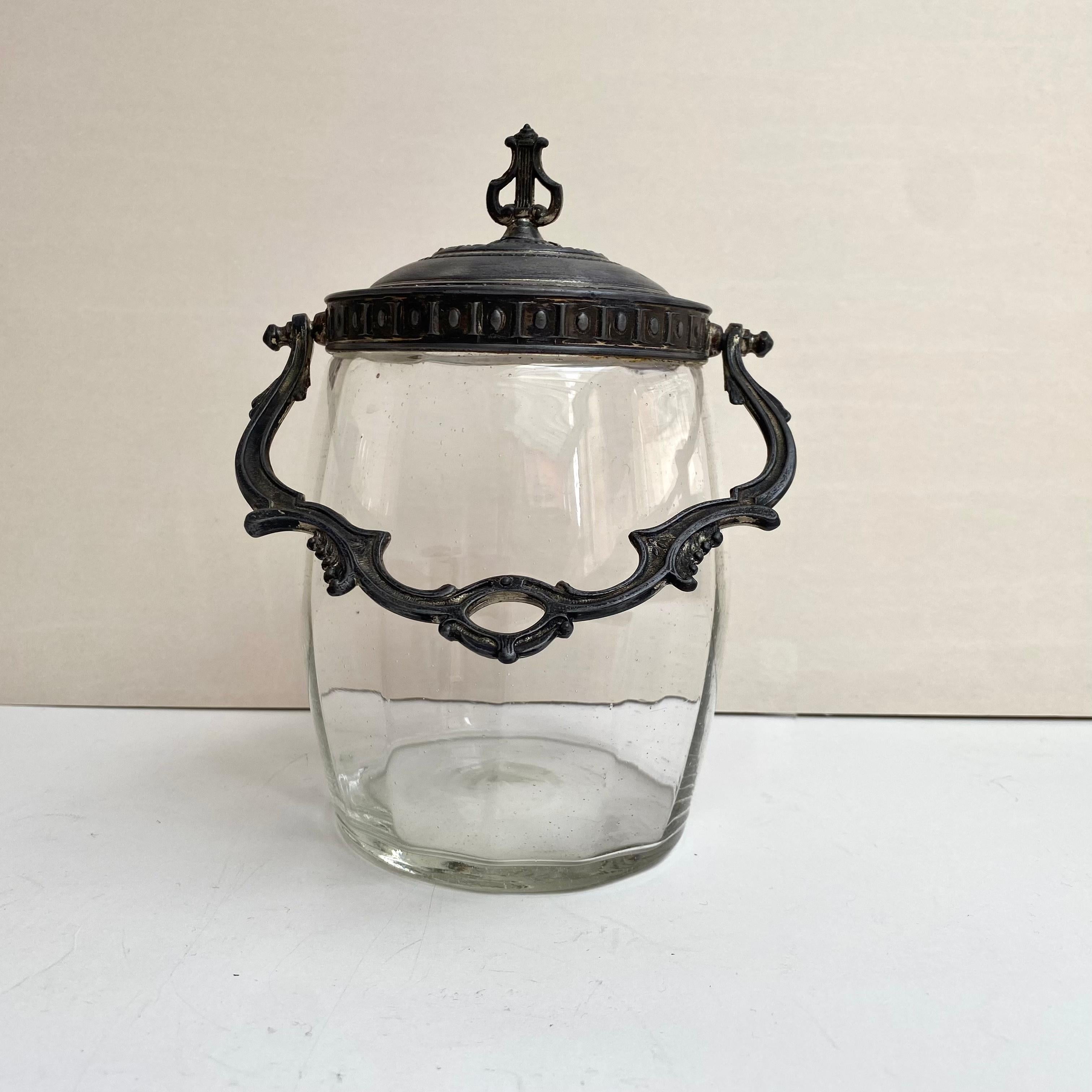 This is remarkably designed Antique cookie jar that would leave your kitchen looking classy and give it a good transition in quality and taste.

This is a metal and glass cookie jar from France, the lid and handle are made of brass and the body of